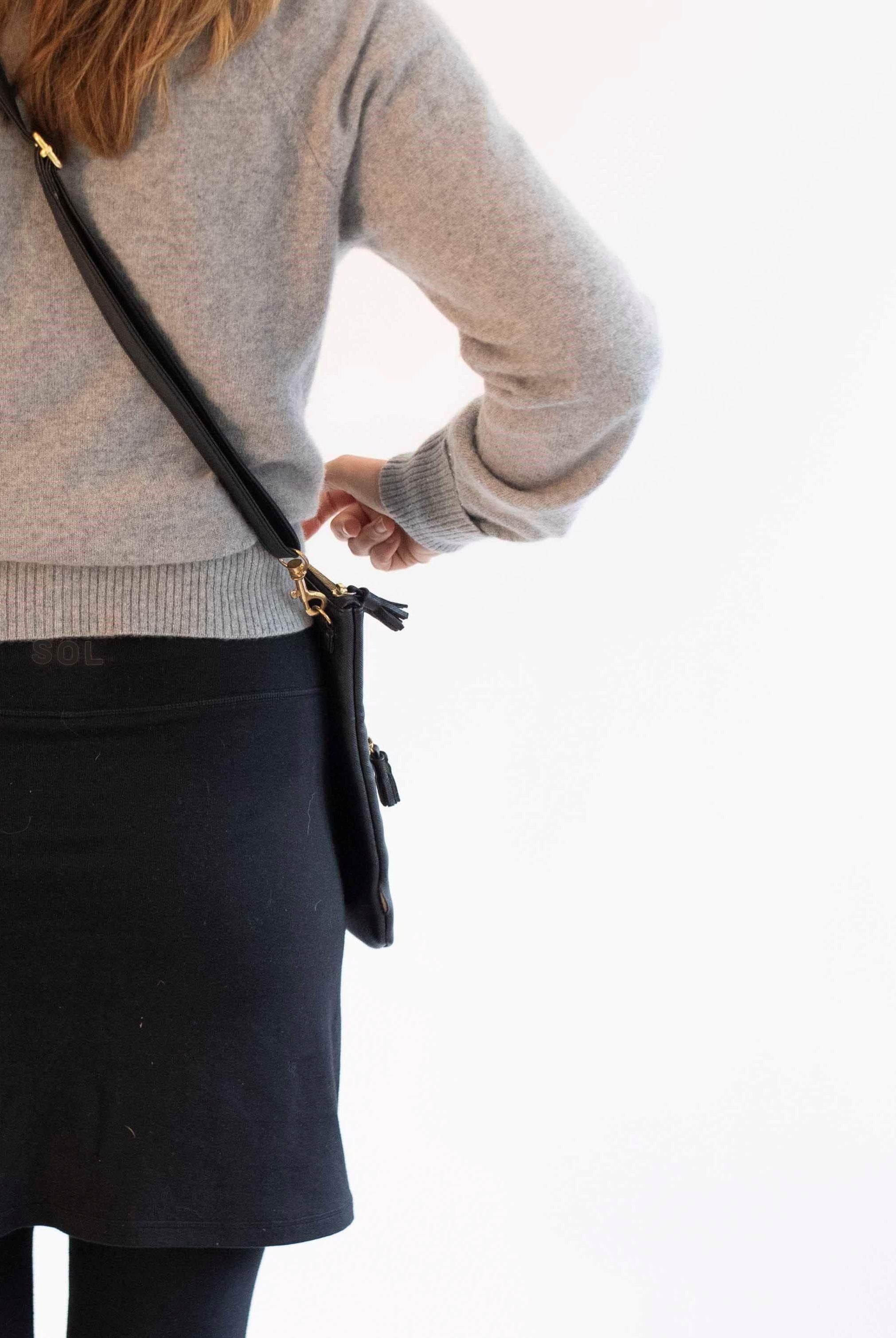 Woman wearing black skirted leggings with 17 inch skirt and cashmere grey turtlneck.-