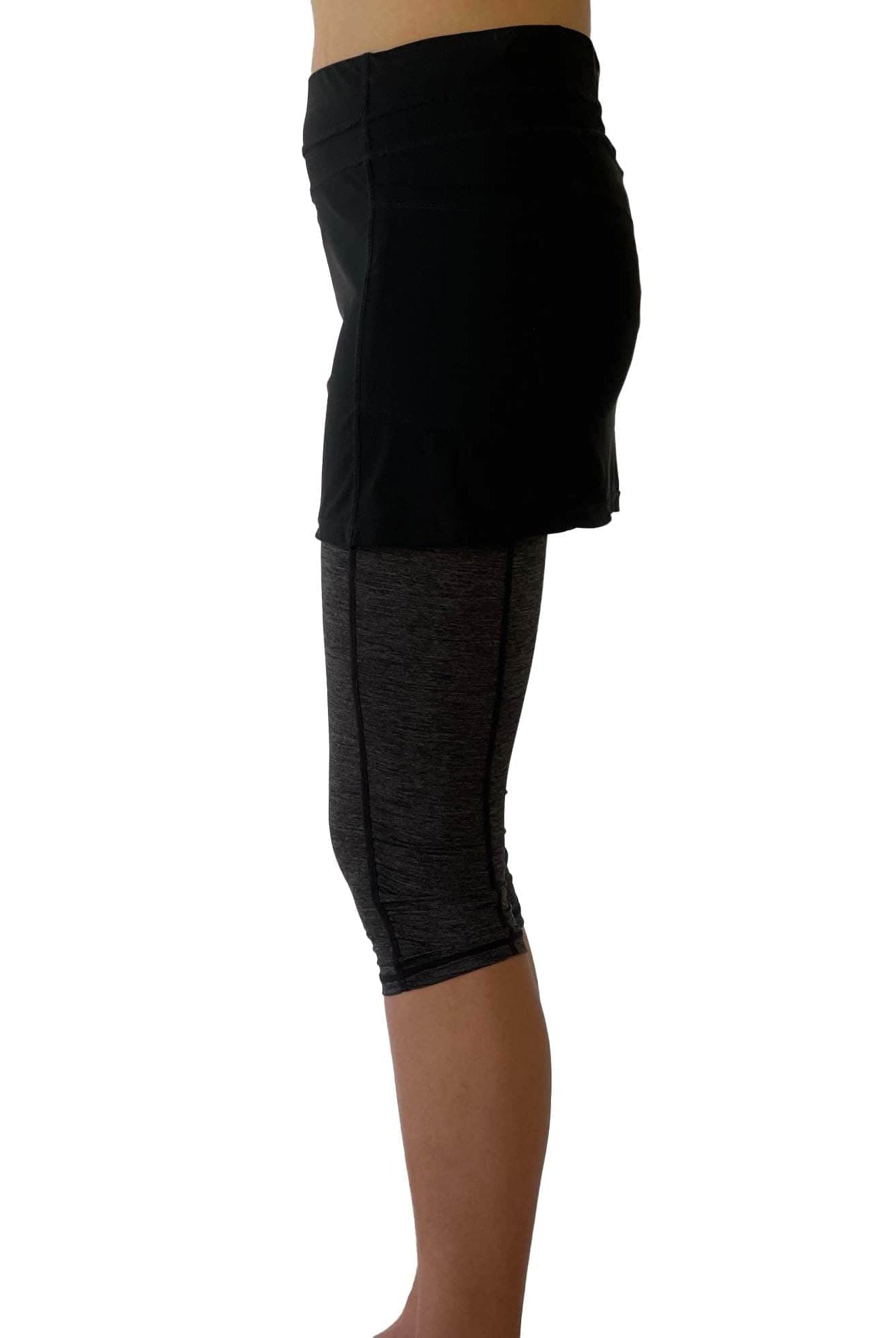 One piece black skirt with heather grey capris length leggings. Photo shows waist down shot of model wearing them from the side.