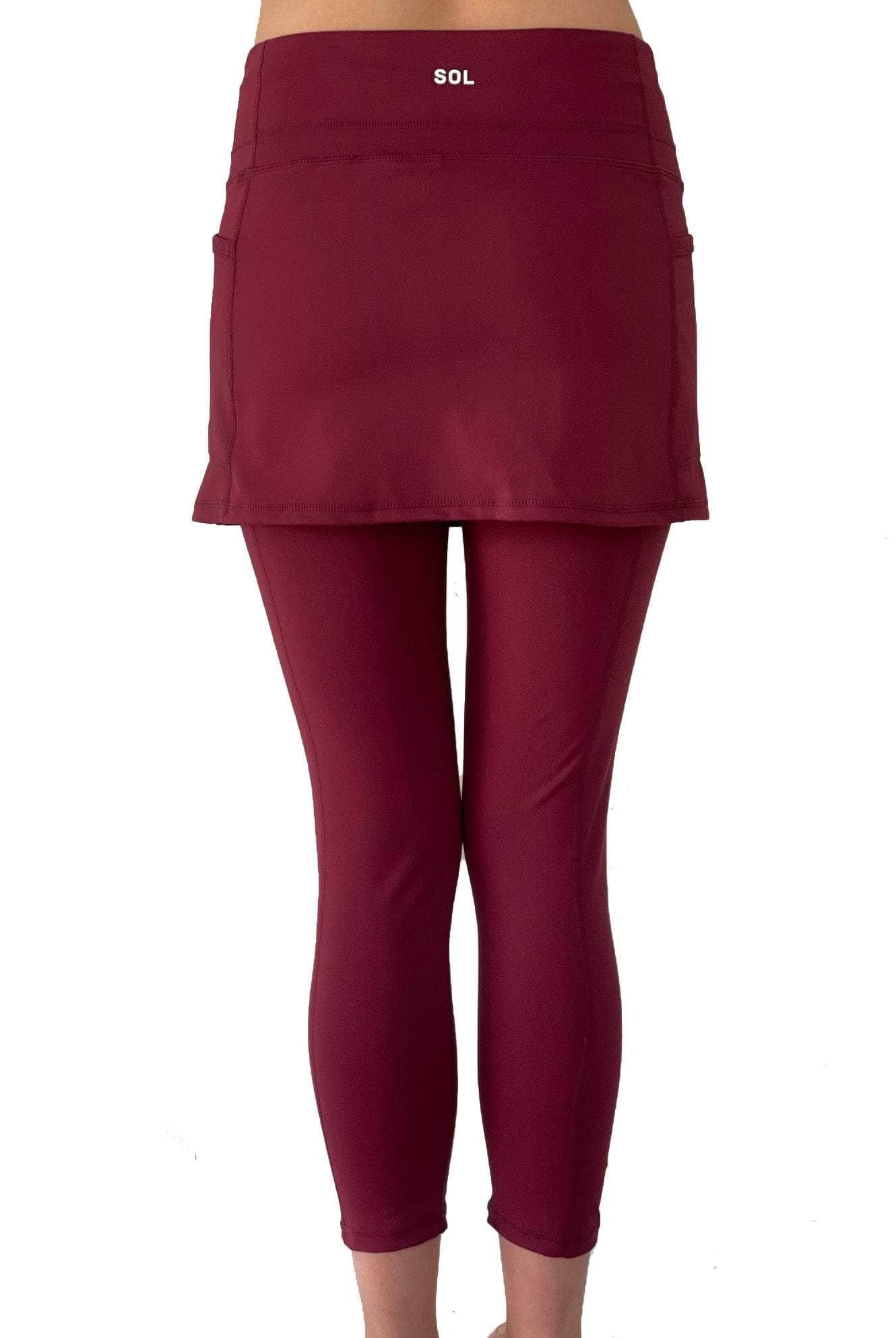 Model from waist down wearing cranberry colored 2-1 skirted leggings, rear view.
