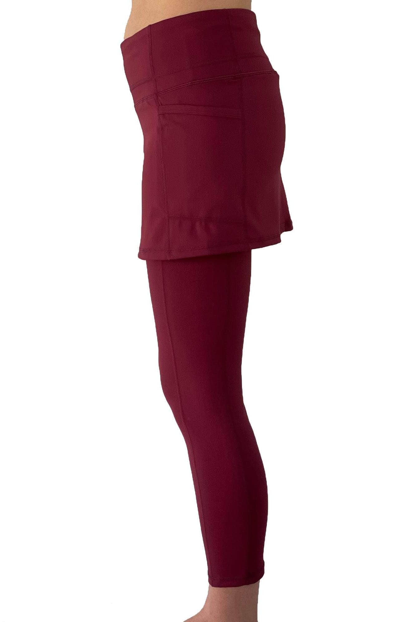 Model from waist down wearing cranberry colored 2-1 skirted leggings, side view.