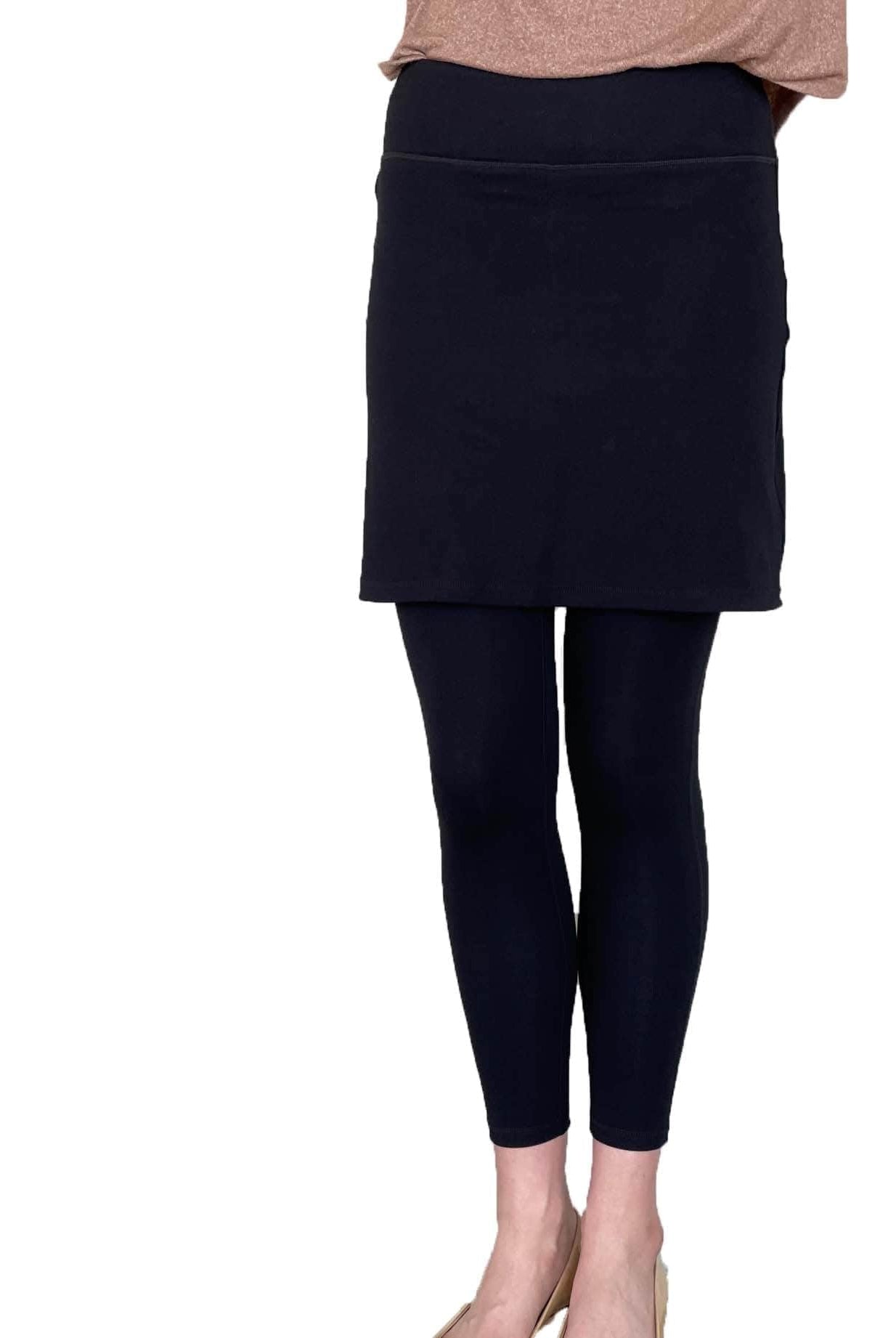 Woman wearing black skirted leggings with 17 inch skirt from front waist down to feet.