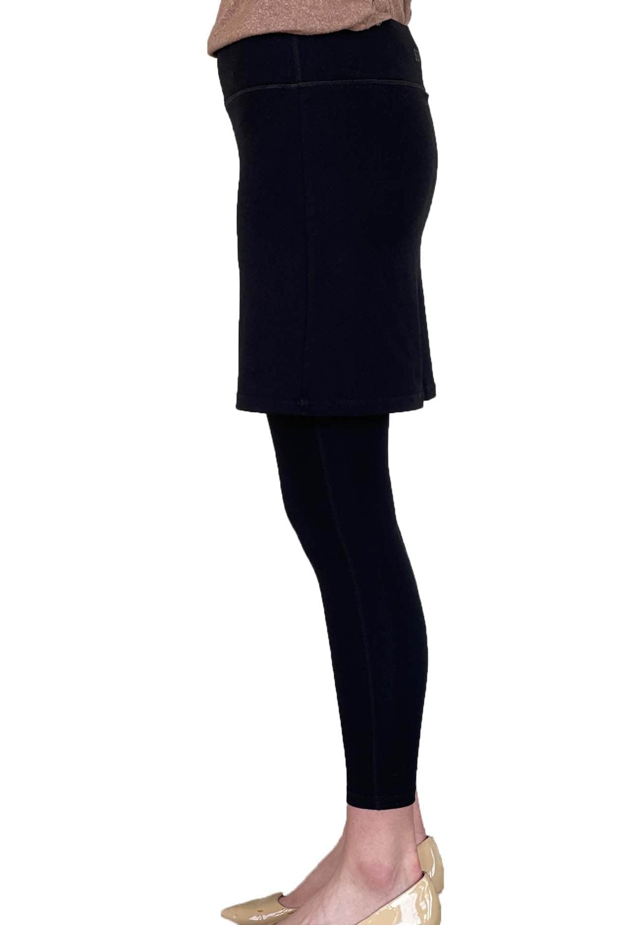 Woman wearing black skirted leggings with 17 inch skirt from side waist down to feet.