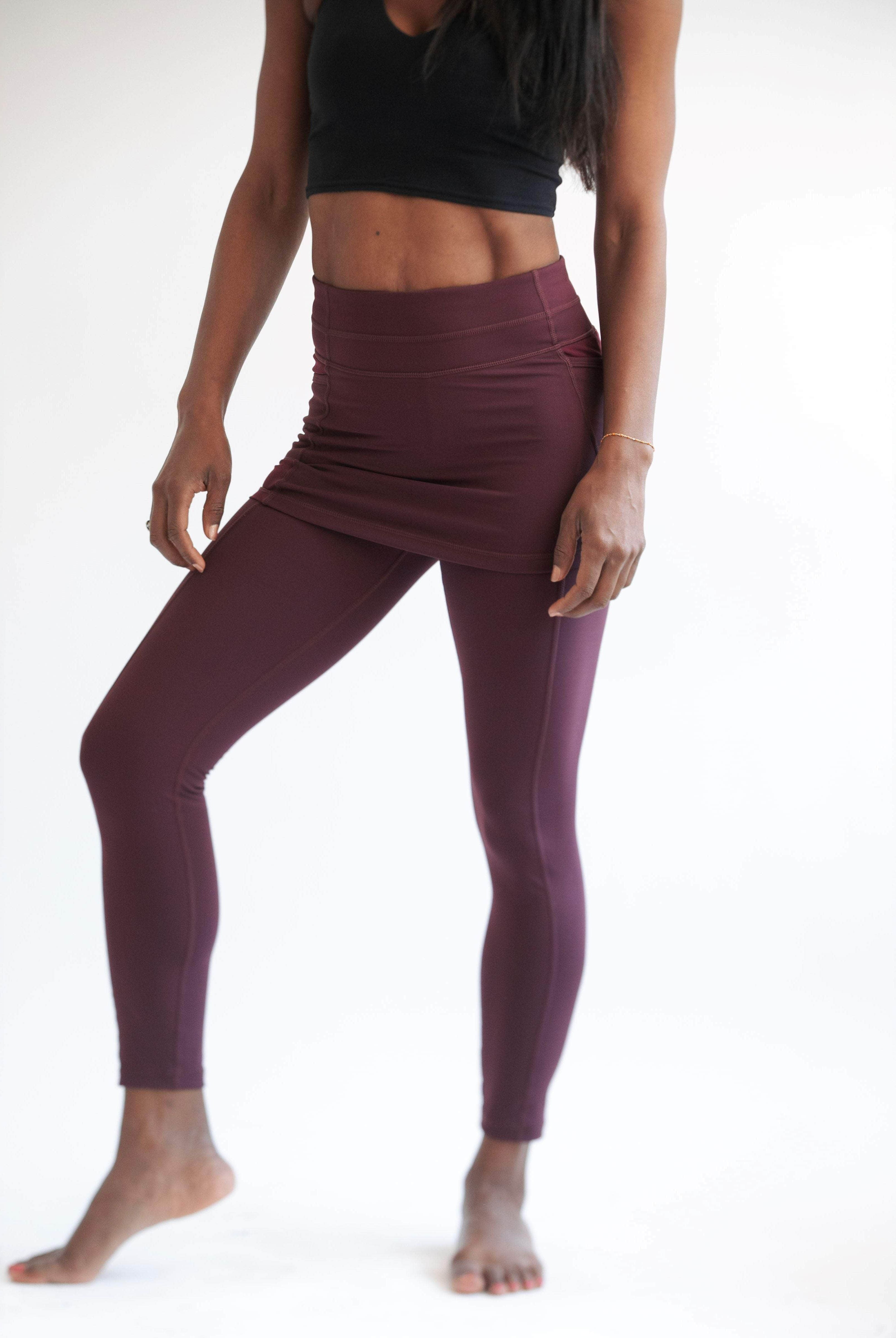 Studio shot of model wearing pretty Maroon colored ankle length skirted leggings with black crop top.