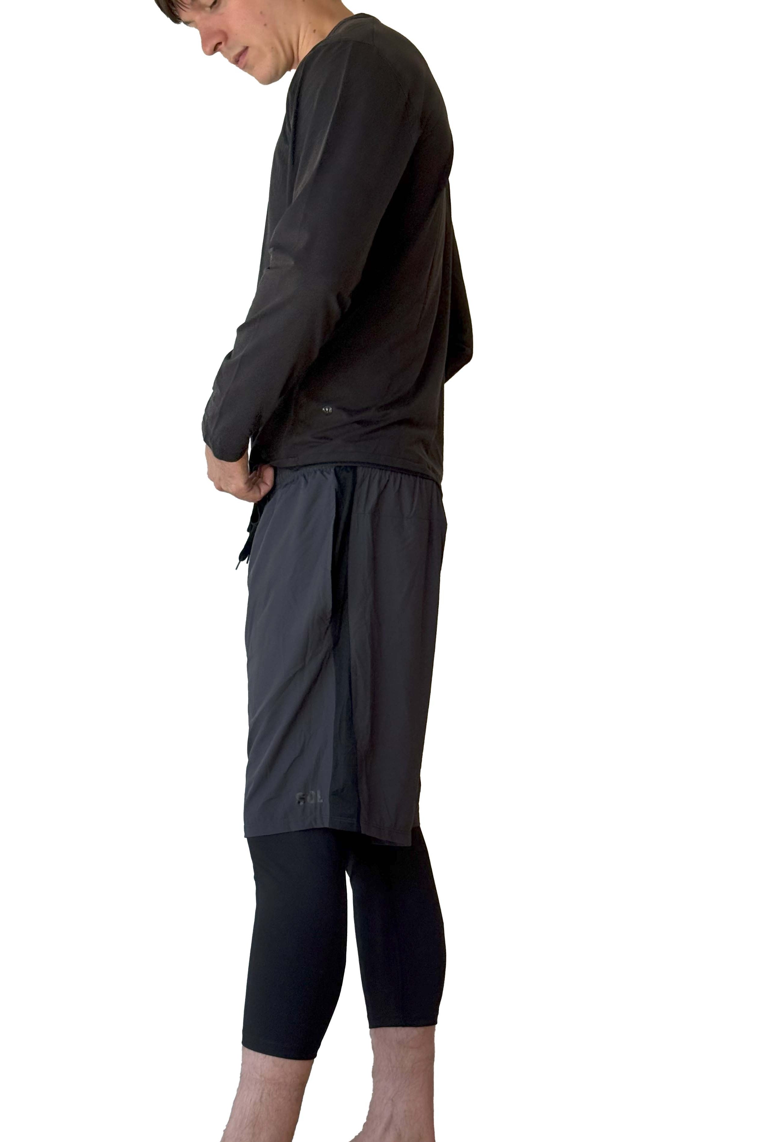 Male model wearing Sol Sister Mister Men's 2-1 Shorts with Midcalf length Leggings taken from side.
