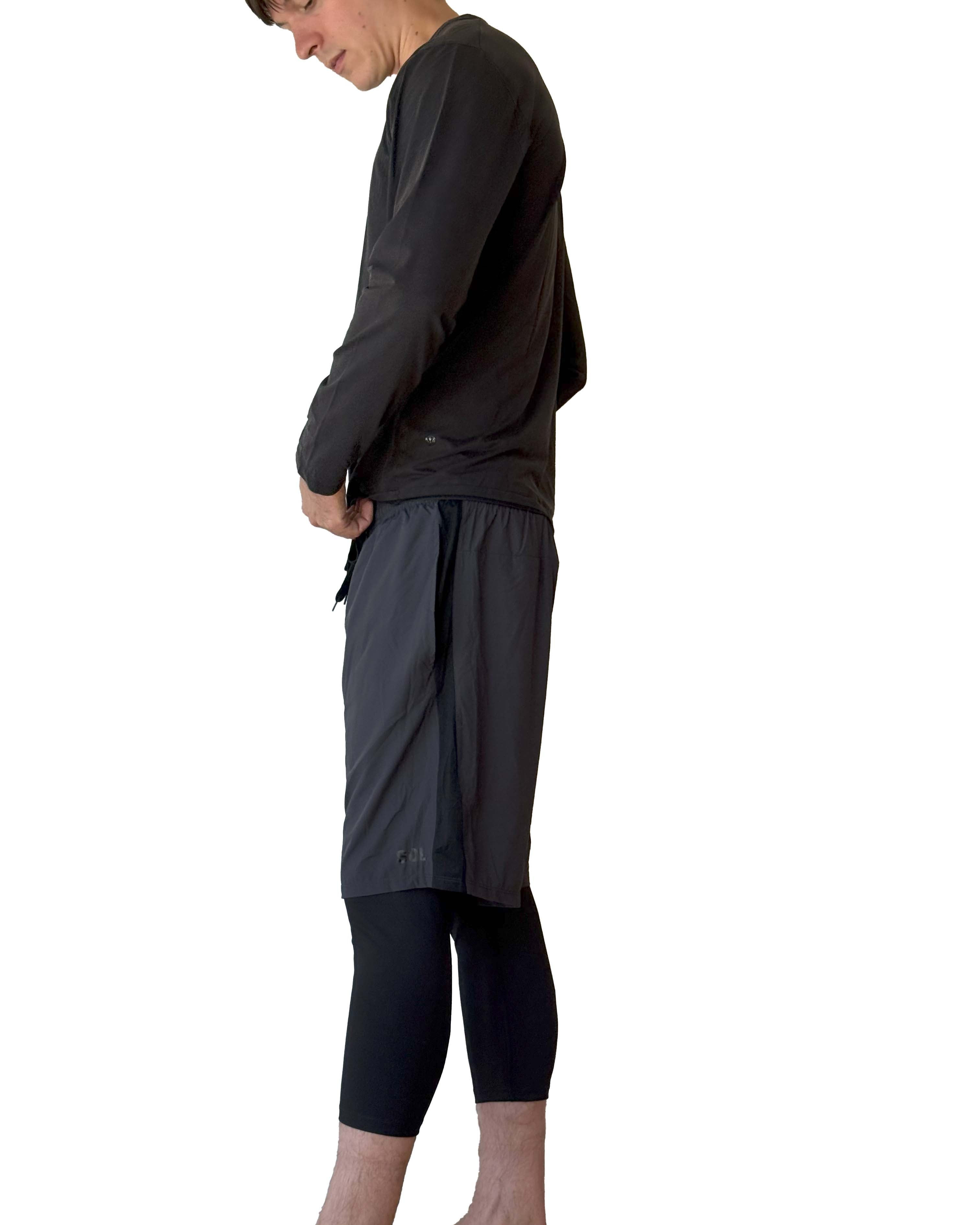 Male model wearing Sol Sister Mister Men's 2-1 Shorts with Midcalf length Leggings taken from side.