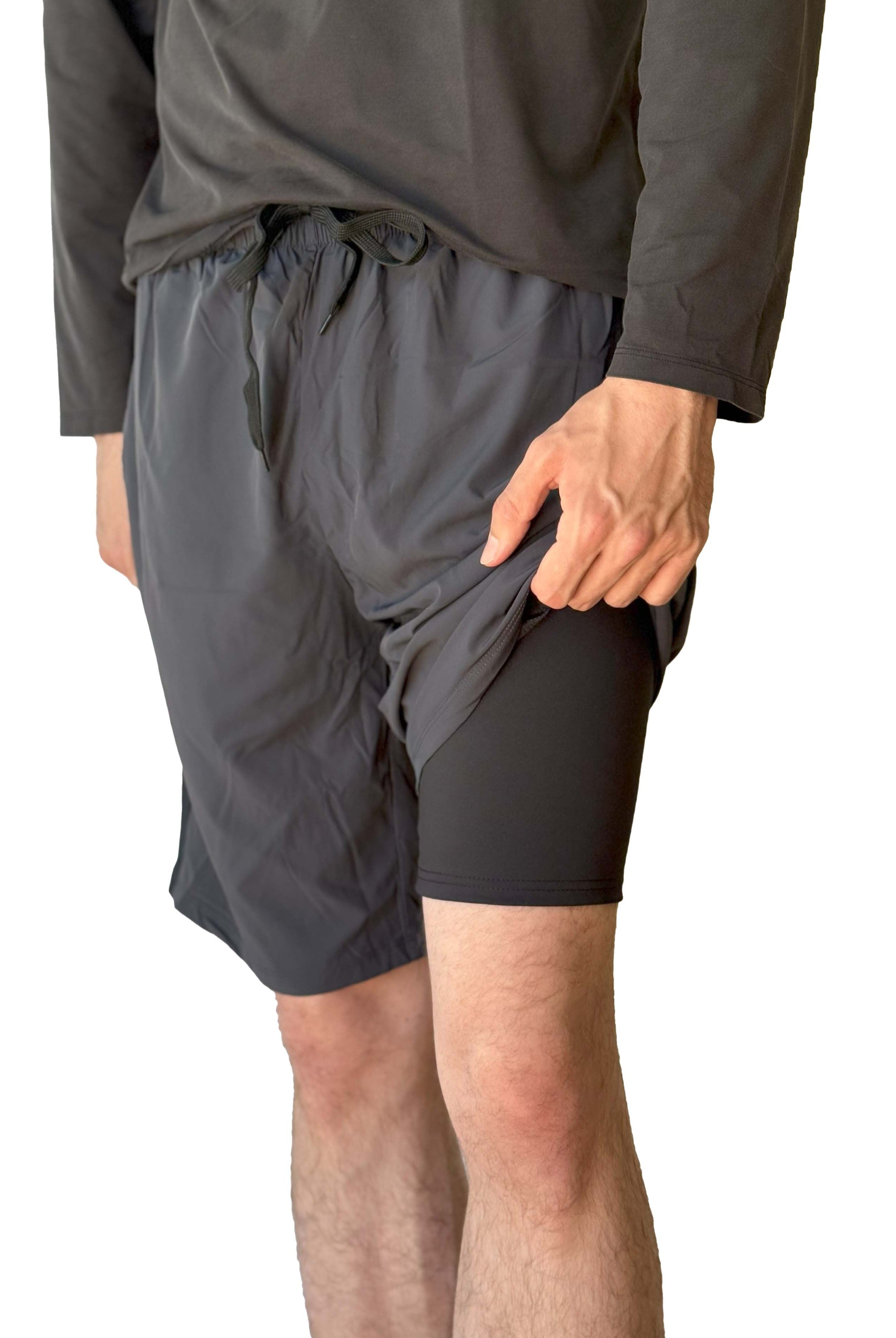 Male model wearing Sol Sister Mister Men's 2-1 Shorts and showing short Leggings under exterior shorts taken waist down from front.