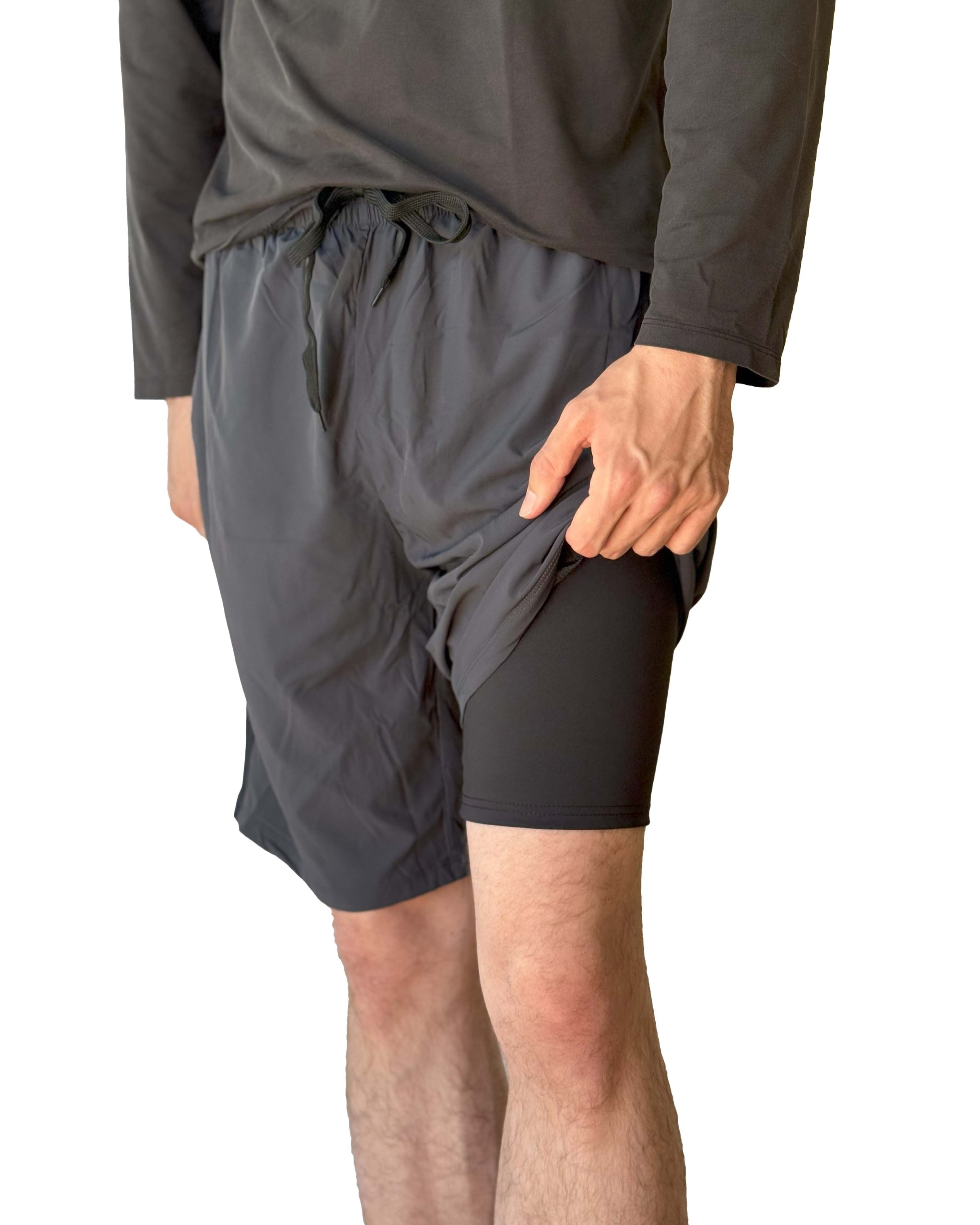 Male model wearing Sol Sister Mister Men's 2-1 Shorts and showing short Leggings under exterior shorts taken waist down from front.