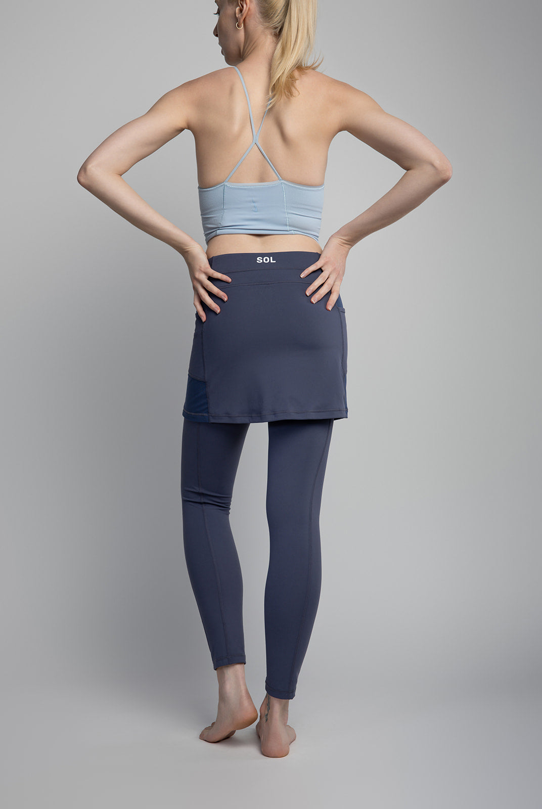 Studio shot of model wearing 2-1 Nordic Dusk colored Ankle-Length Skirted Leggings - Sol Sister Sport