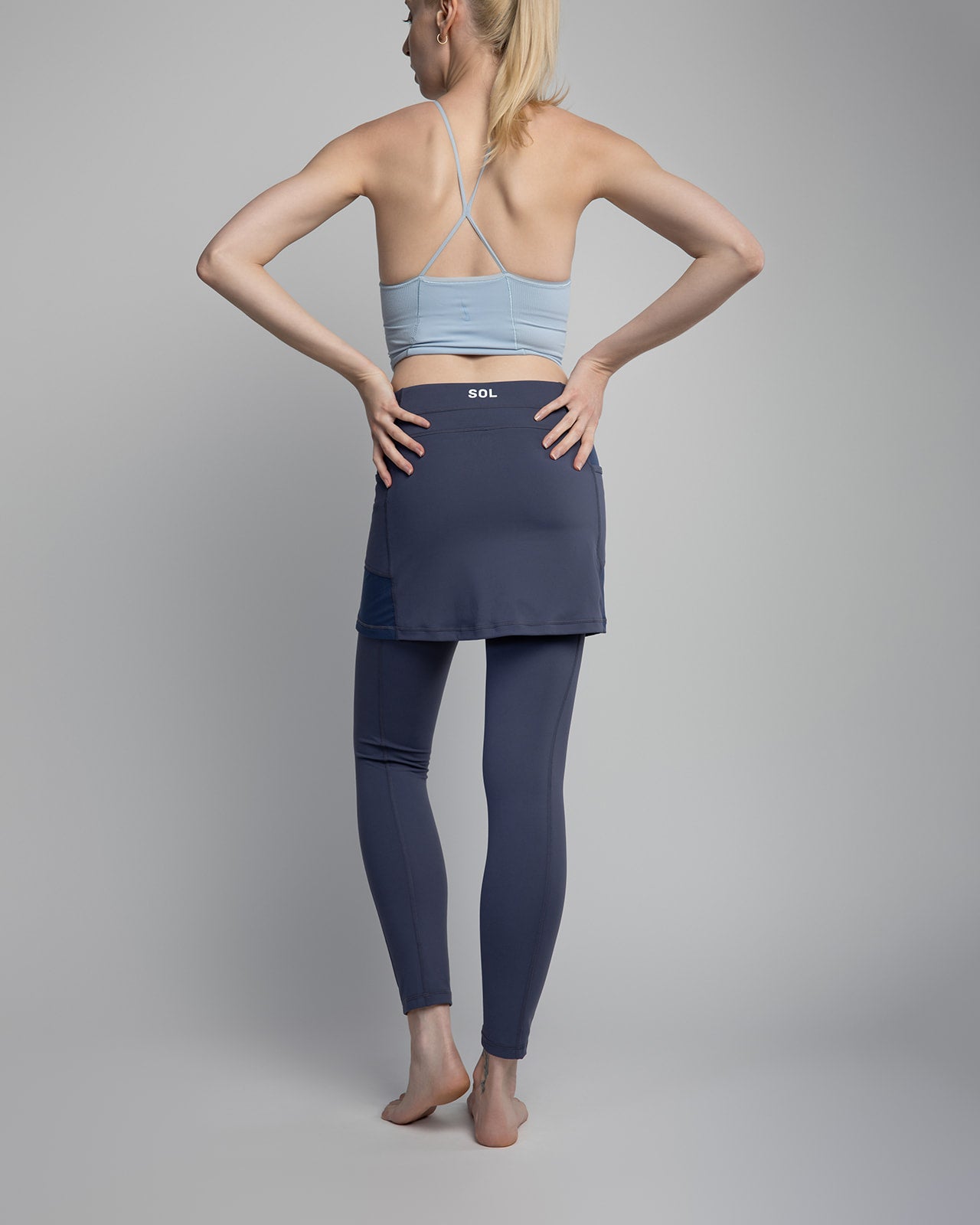 Studio shot of model wearing 2-1 Nordic Dusk colored Ankle-Length Skirted Leggings - Sol Sister Sport