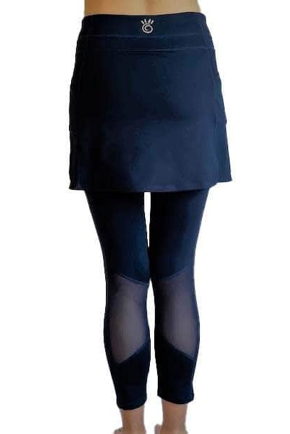 Woman wearing Navy mid-calf legging length skirted leggings from waist down with white background from back view.