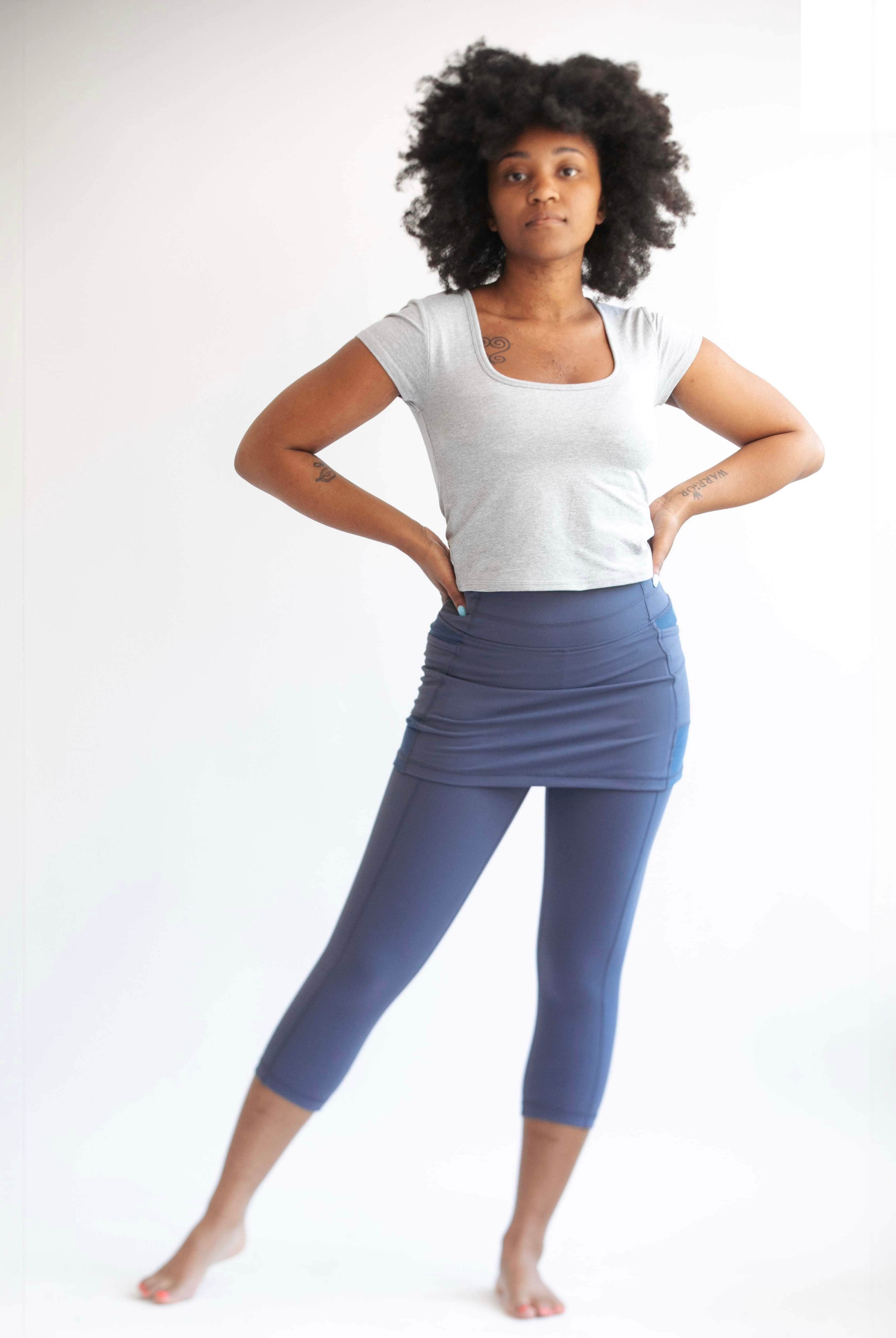 Studio shot of model wearing capris length blue grey skirted leggings - Sol Sister Sport.
