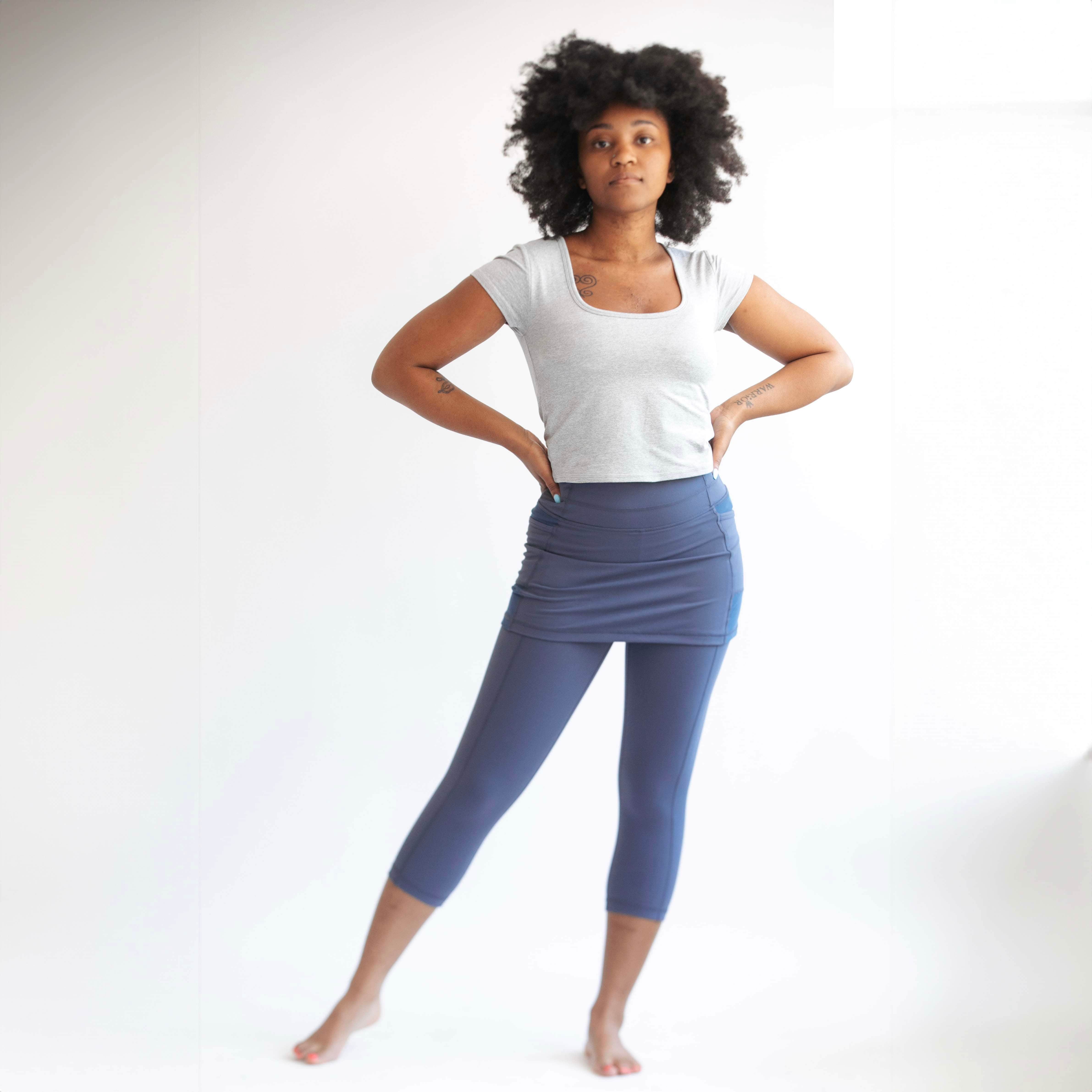 Studio shot of model wearing capris length blue grey skirted leggings - Sol Sister Sport.