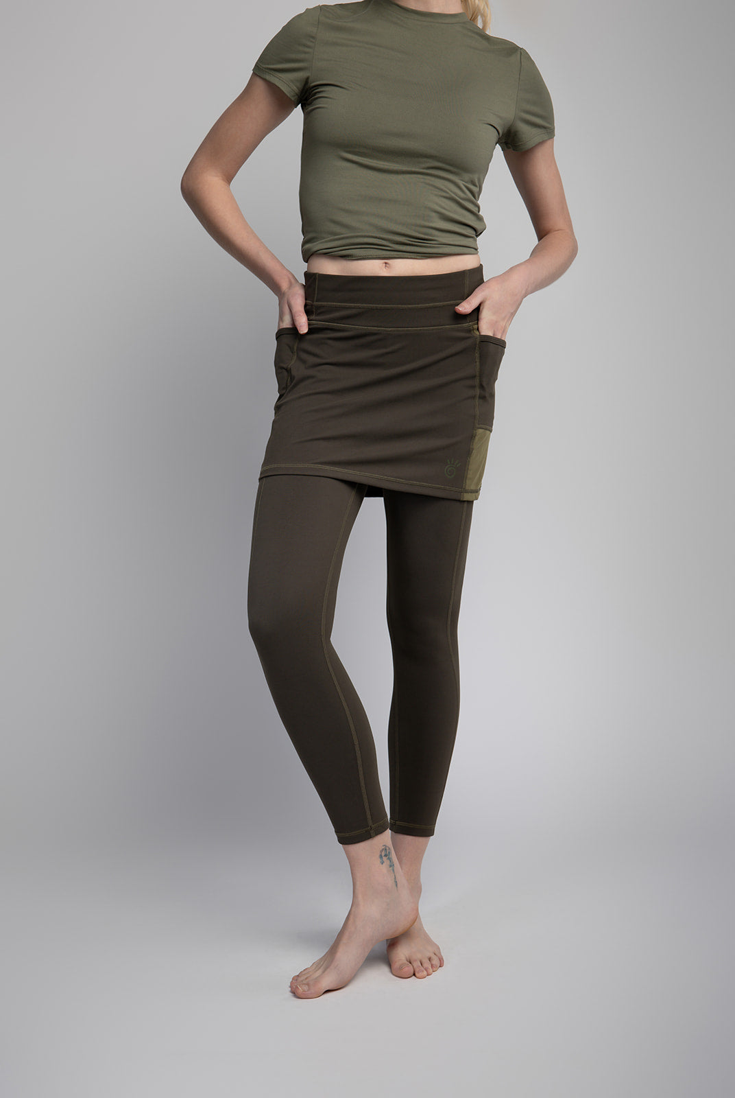 Studio shot of Model wearing 7/8ths length pretty olive skirted leggings