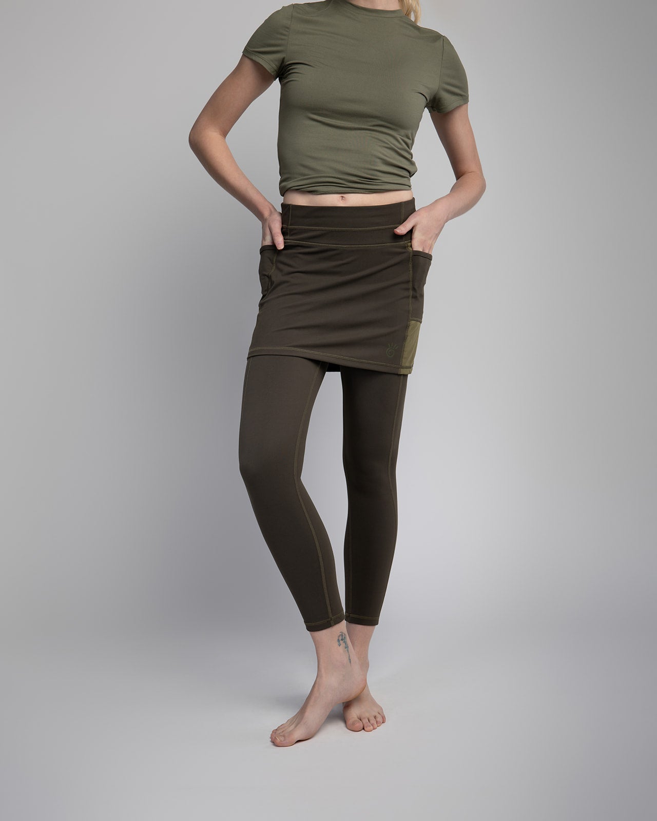 Studio shot of Model wearing 7/8ths length pretty olive skirted leggings