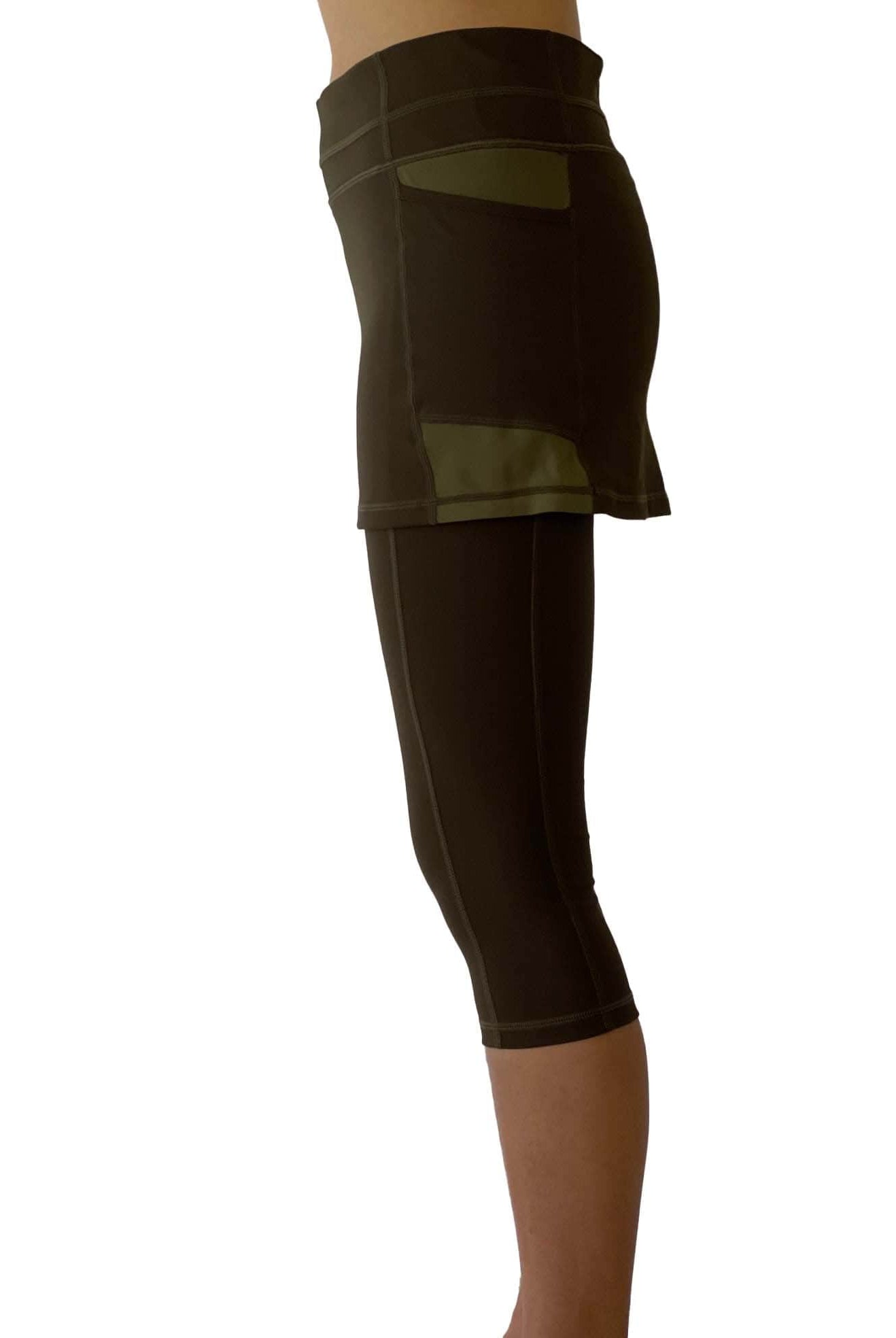 Studio shot of model wearing olive leggings with attached olive skirt from side