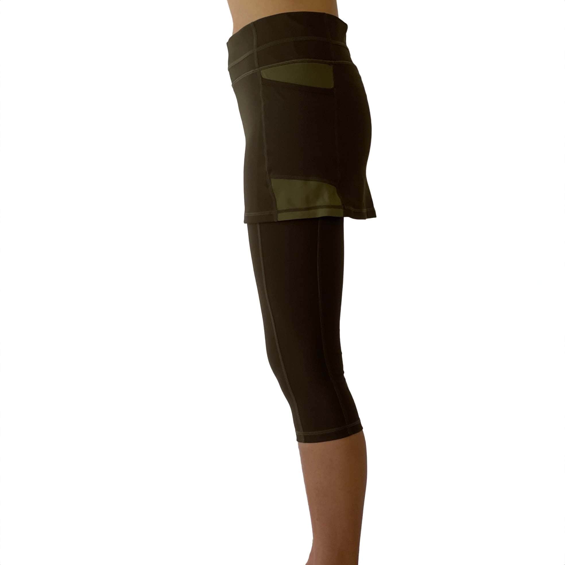 Studio shot of model wearing olive leggings with attached olive skirt from side