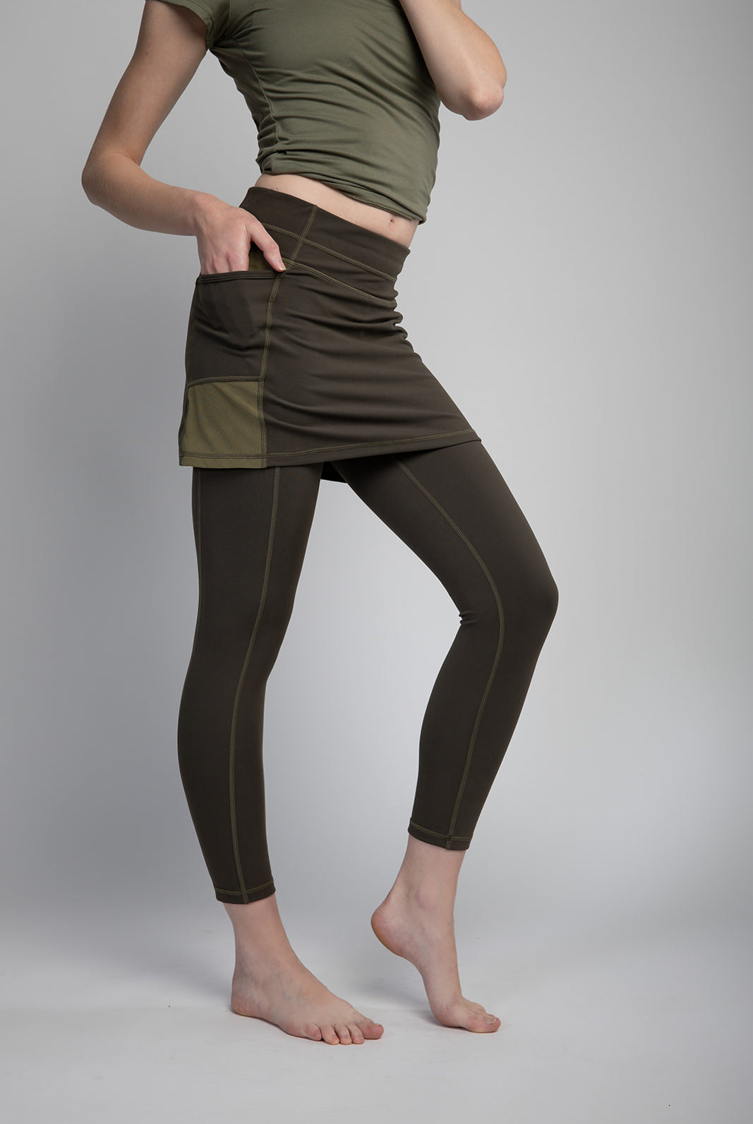 Studio shot of Model wearing 7/8ths length pretty olive skirted leggings