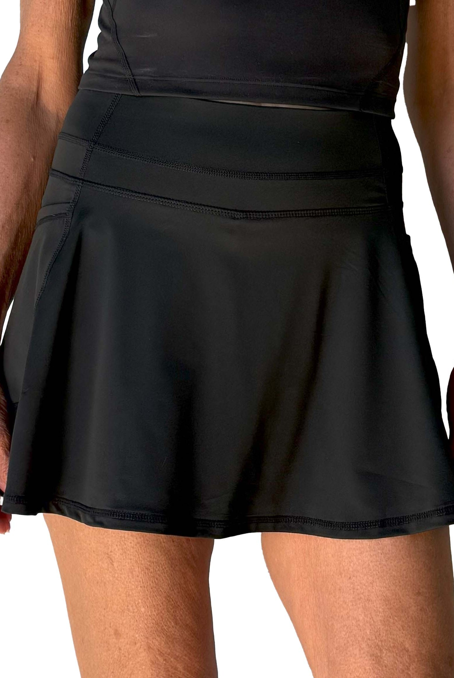 Black flared skort worn by a person on a white background