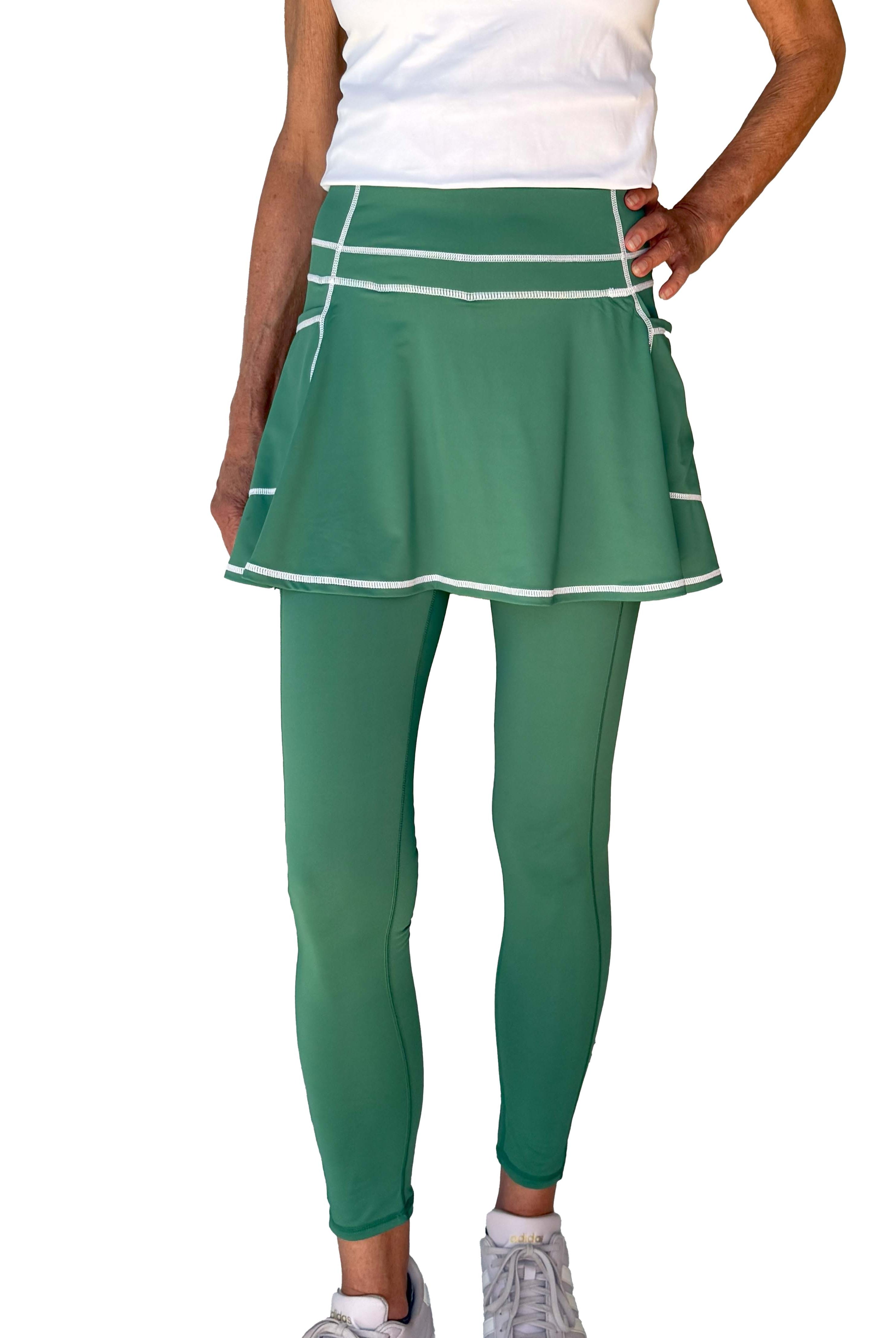 Green athletic skirted leggings set on a white background