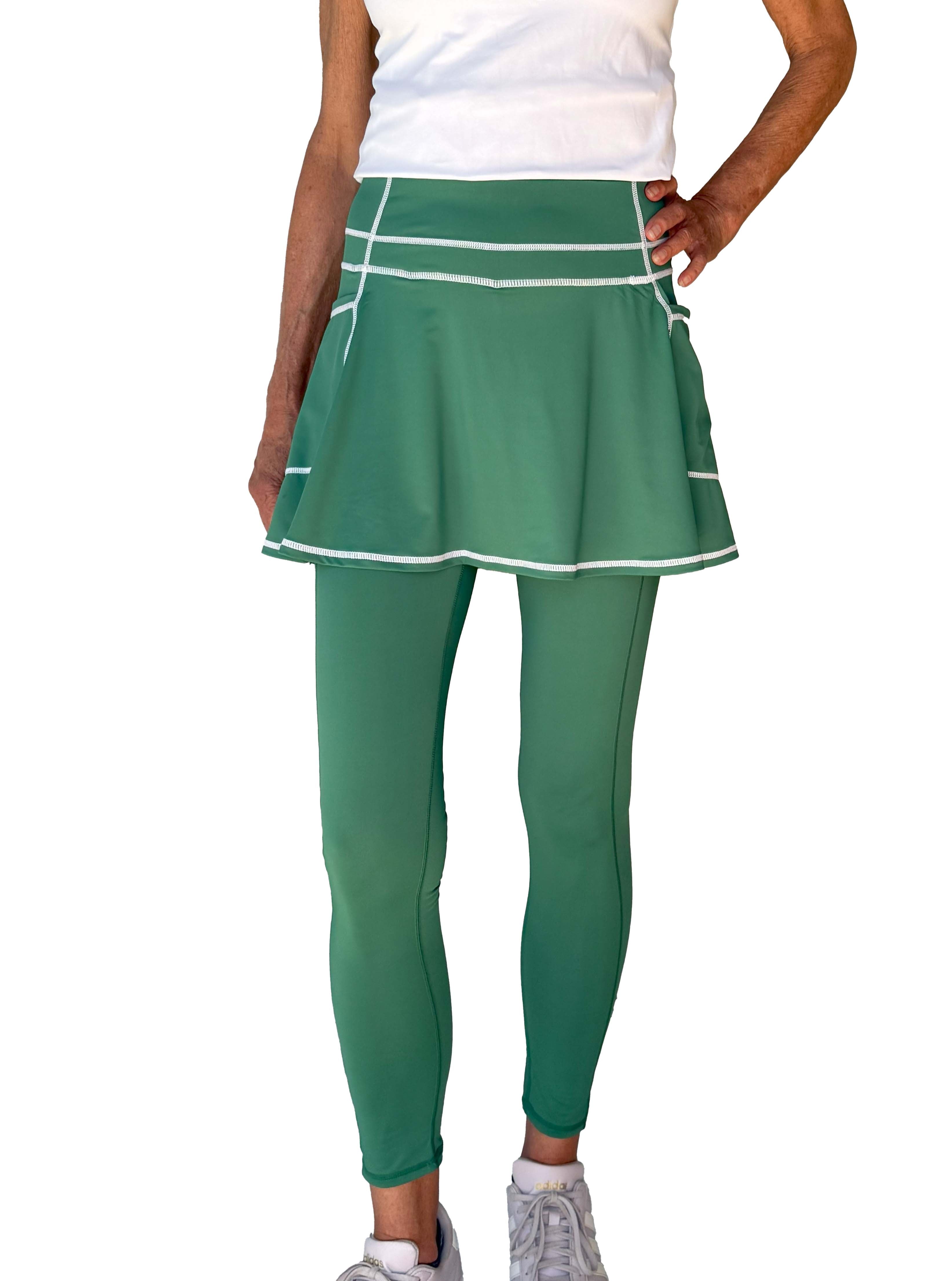 Green athletic skirted leggings set on a white background