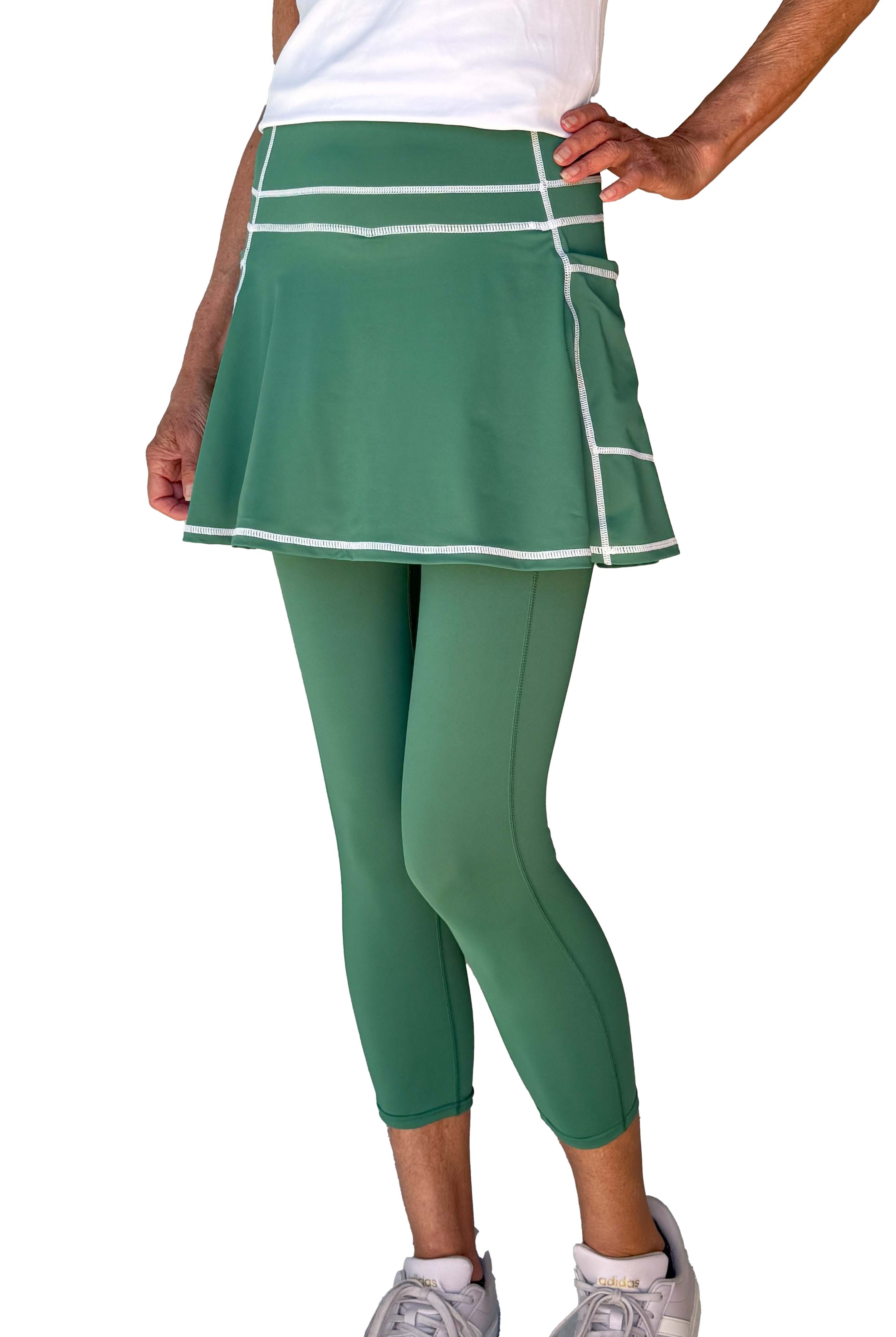 Green athletic skirted midcalf length leggings set on a white background