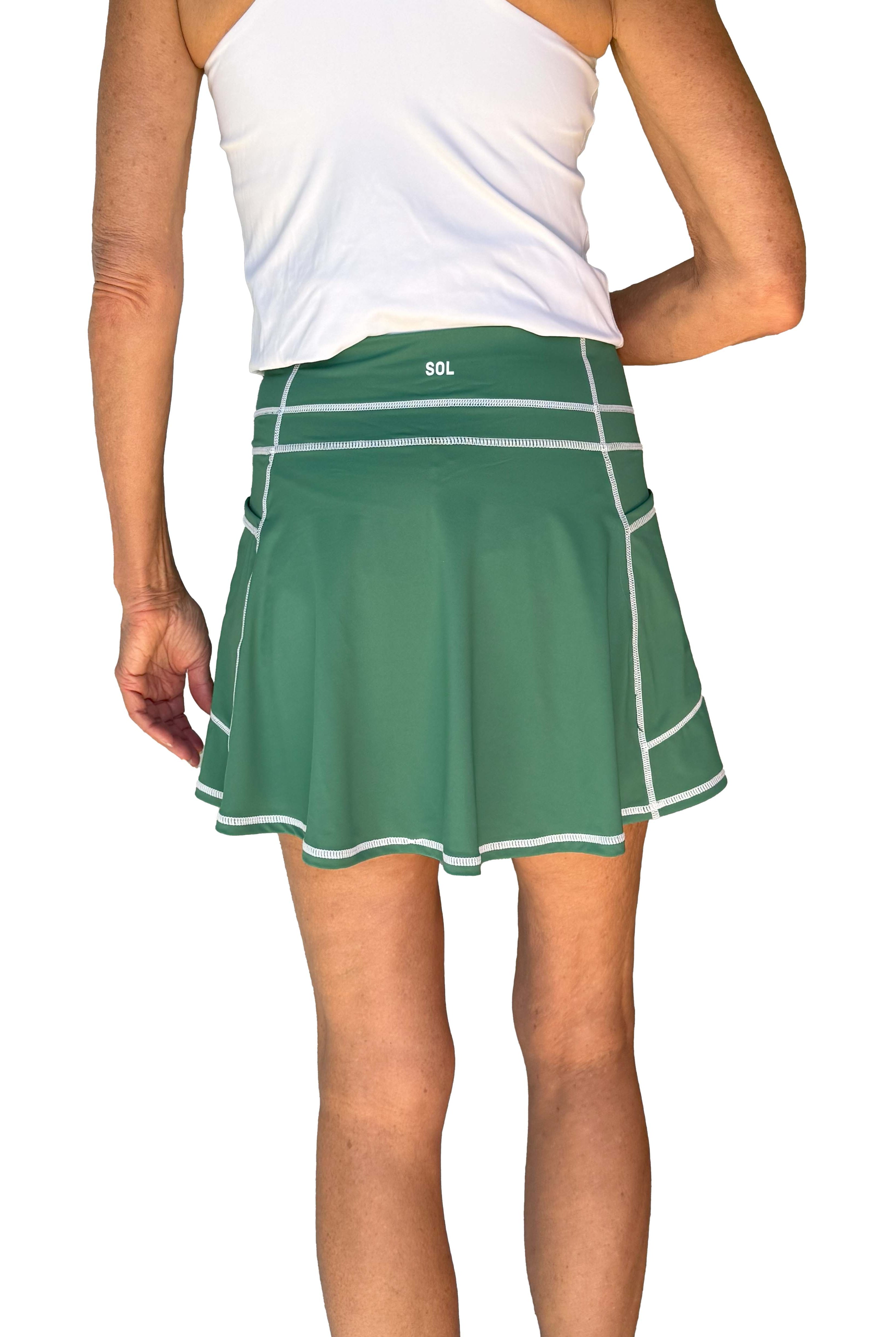 Back view of Green athletic skort worn by a person on a white background