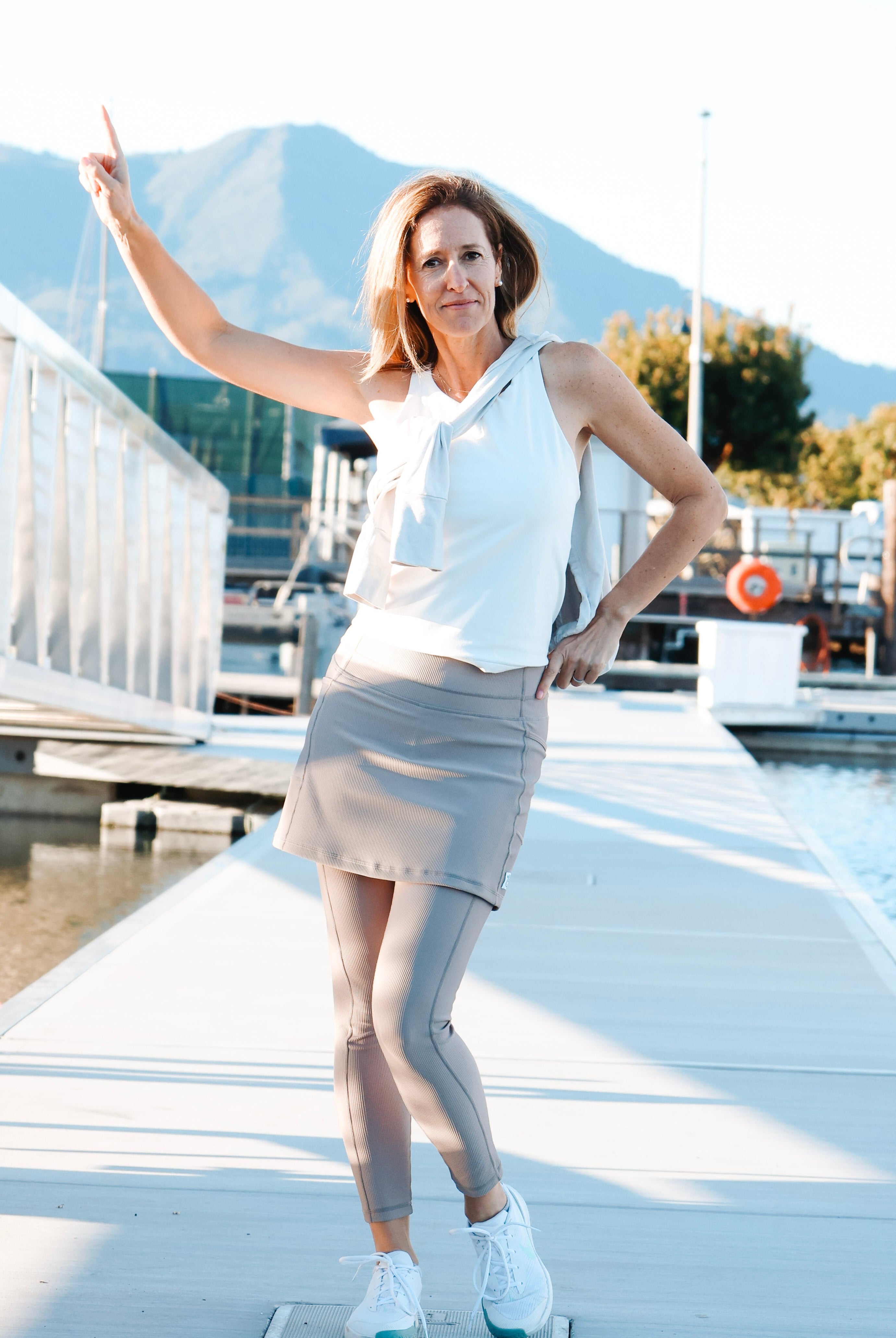 Woman standing on a dock with mountains in the background