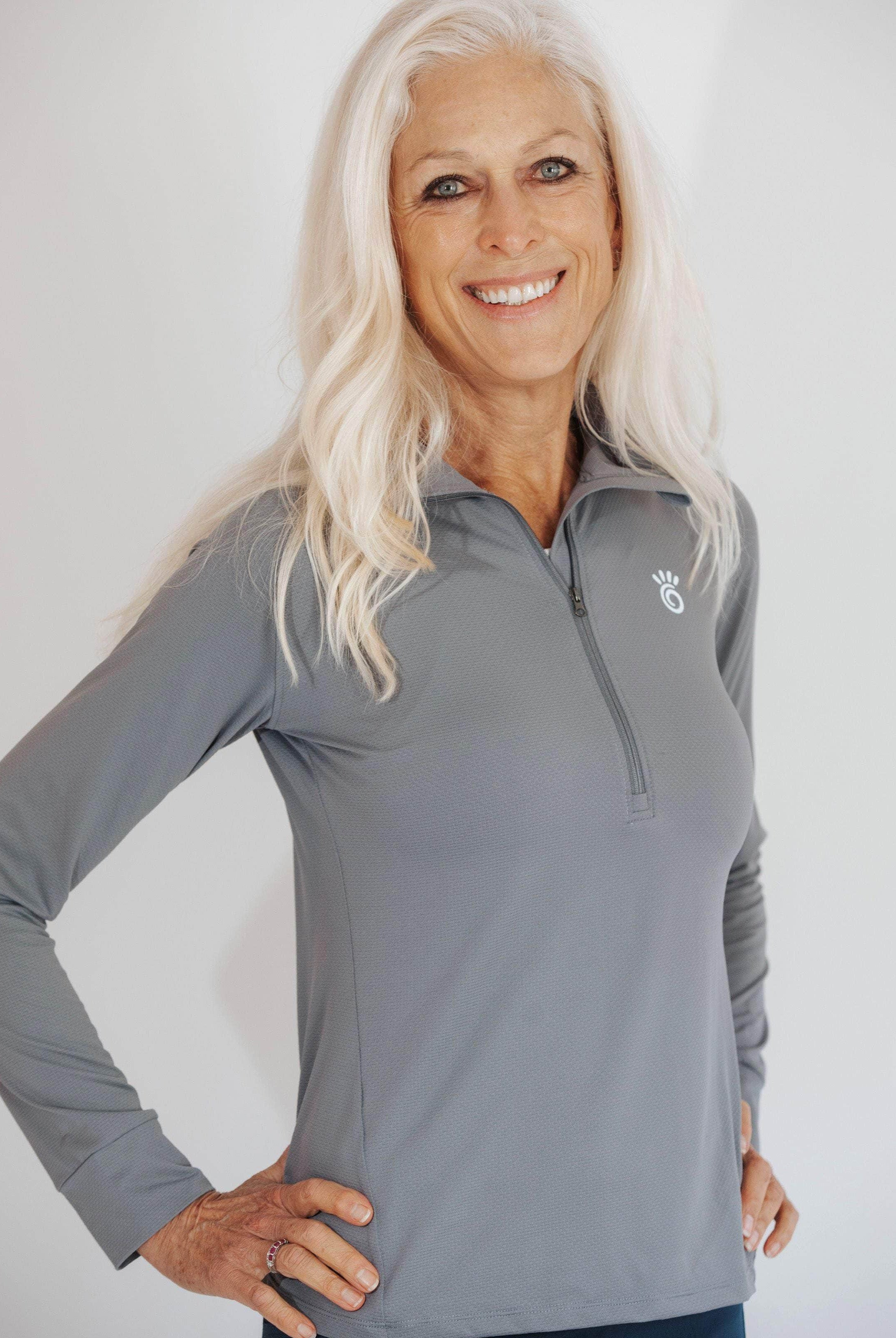 Close up shot of silver haired model wearing a pretty grey 1/4 zip athletic shirt.