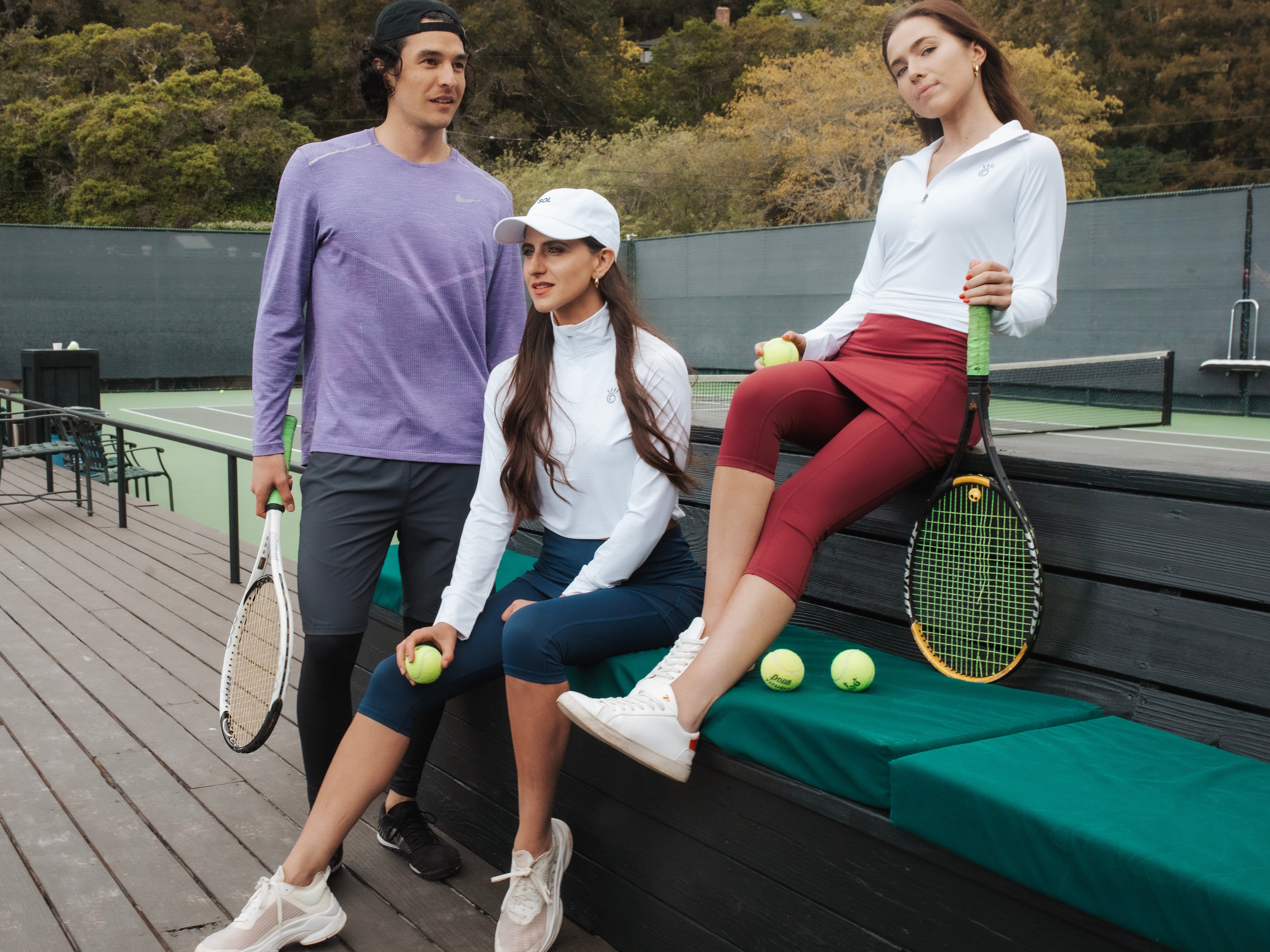 Tennis players sitting near court women wearing skirted leggings
