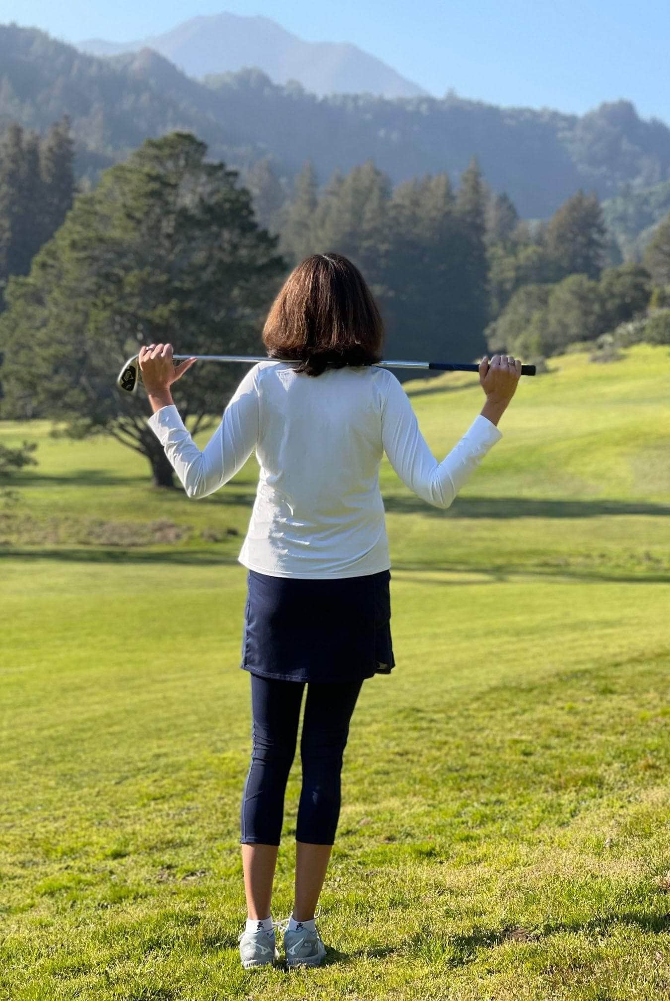 2-1 Original Skirted Mid-calf Length Leggings in Navy Blue - Model holding Golf Club looking at course - Sol Sister Sport
