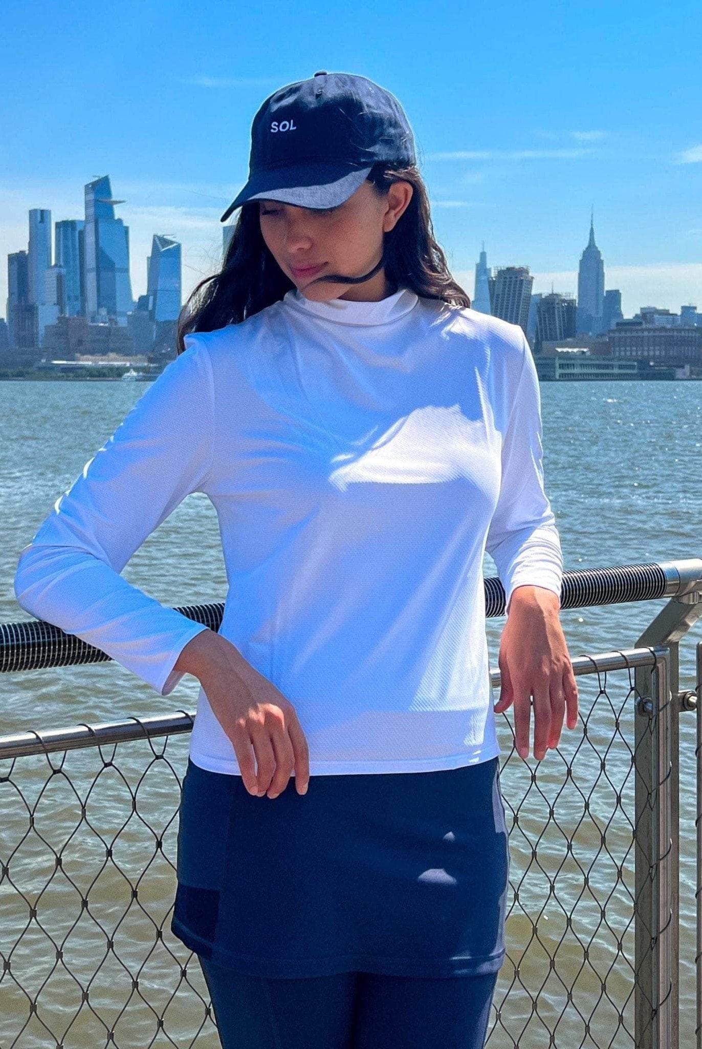 Navy Blue Sol Baseball Cap - Model posing on sunny day with NYC in background - Sol Sister Sport