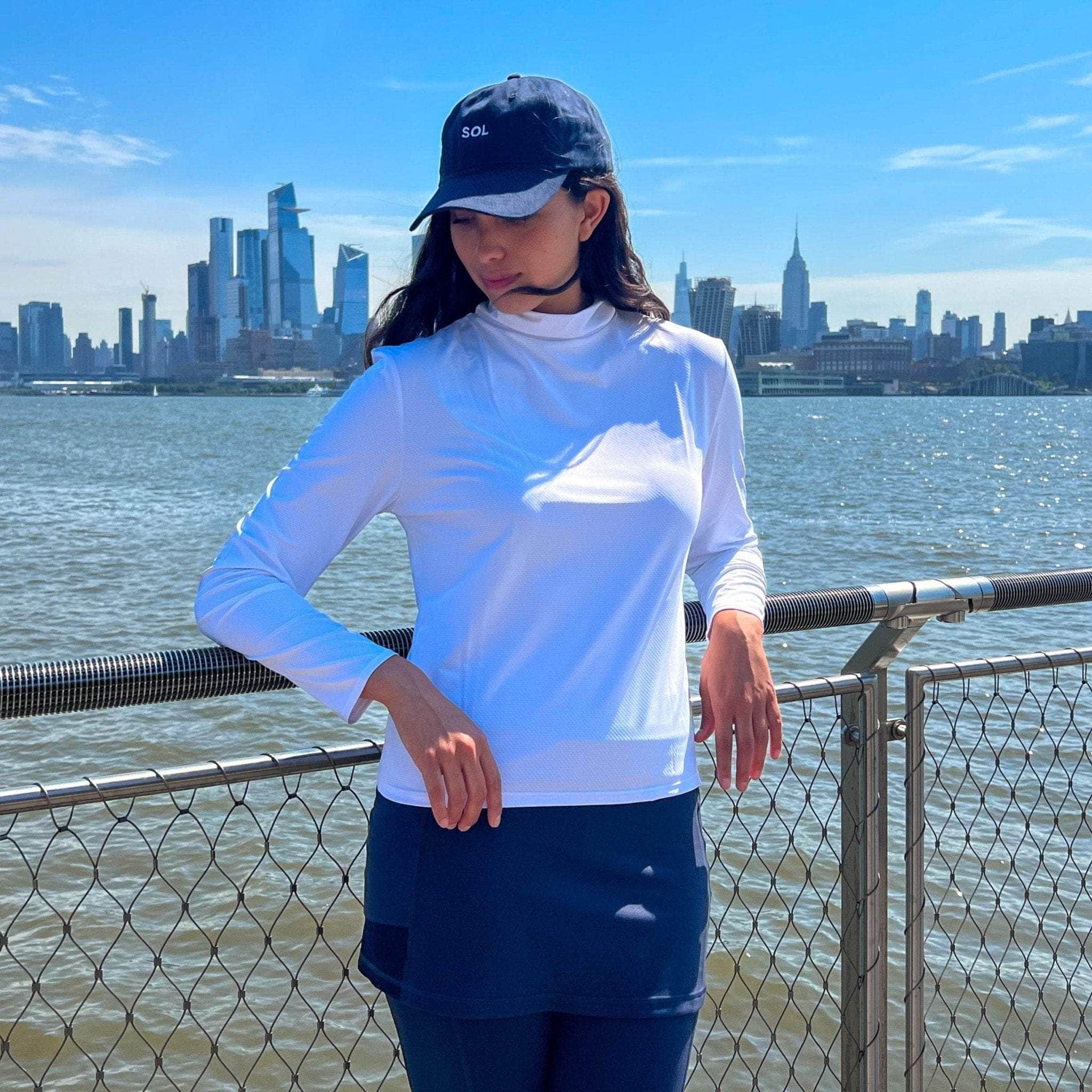 Navy Blue Sol Baseball Cap - Model posing on sunny day with NYC in background - Sol Sister Sport