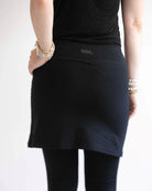 Back view of Woman wearing black skirted leggings with 17 inch skirt upper rear