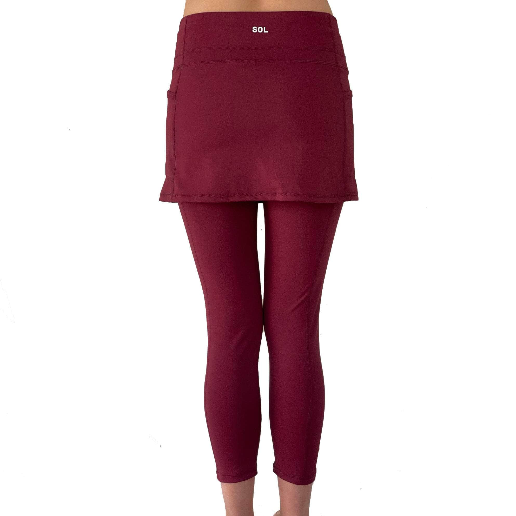 Model from waist down wearing cranberry colored 2-1 skirted leggings, rear view.