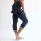 Studio shot of model from waist down wearing Midnight Capris 2-1 Skirted Leggings from side