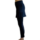 Woman wearing Navy mid-calf legging length skirted leggings from waist down with white background from side view.