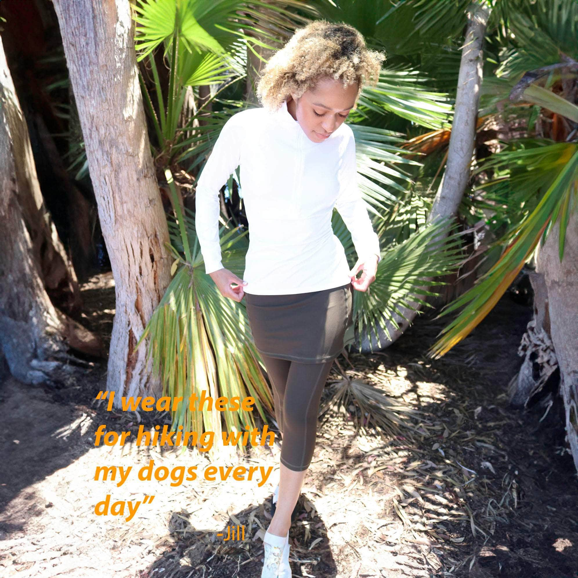 Model in tropical forest wearing capris length olive skirted leggings with white athletic top - Sol SIster Sport