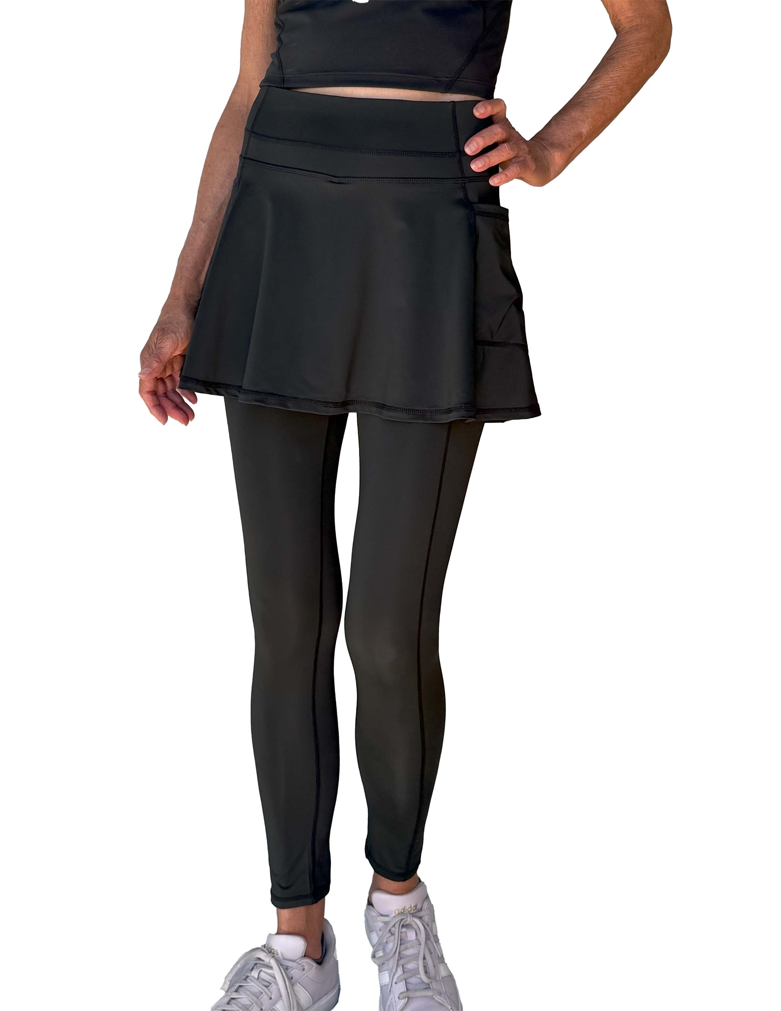 Person wearing a black athletic outfit with 2-1 skirted leggings on a white background