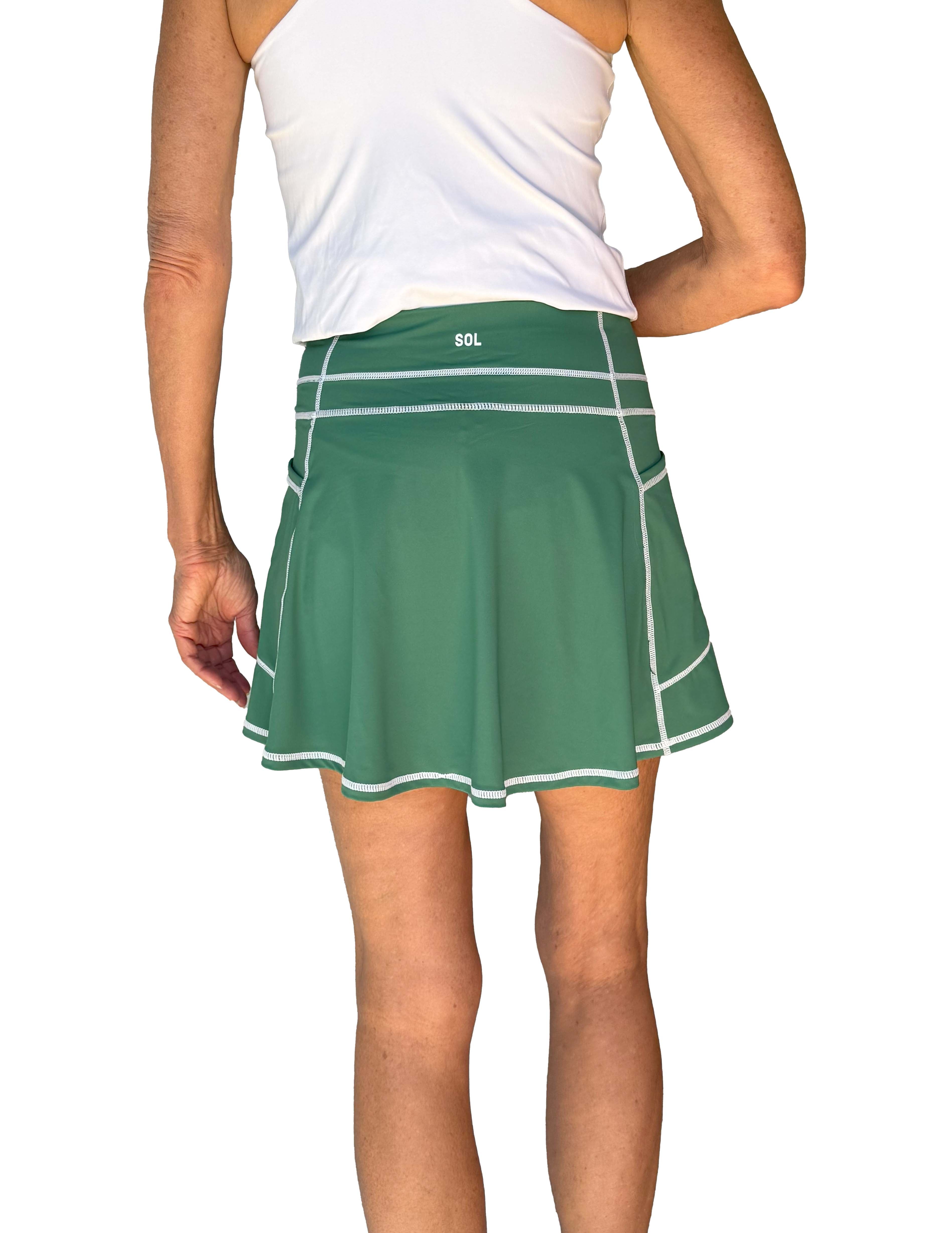 Back view of Green athletic skort worn by a person on a white background