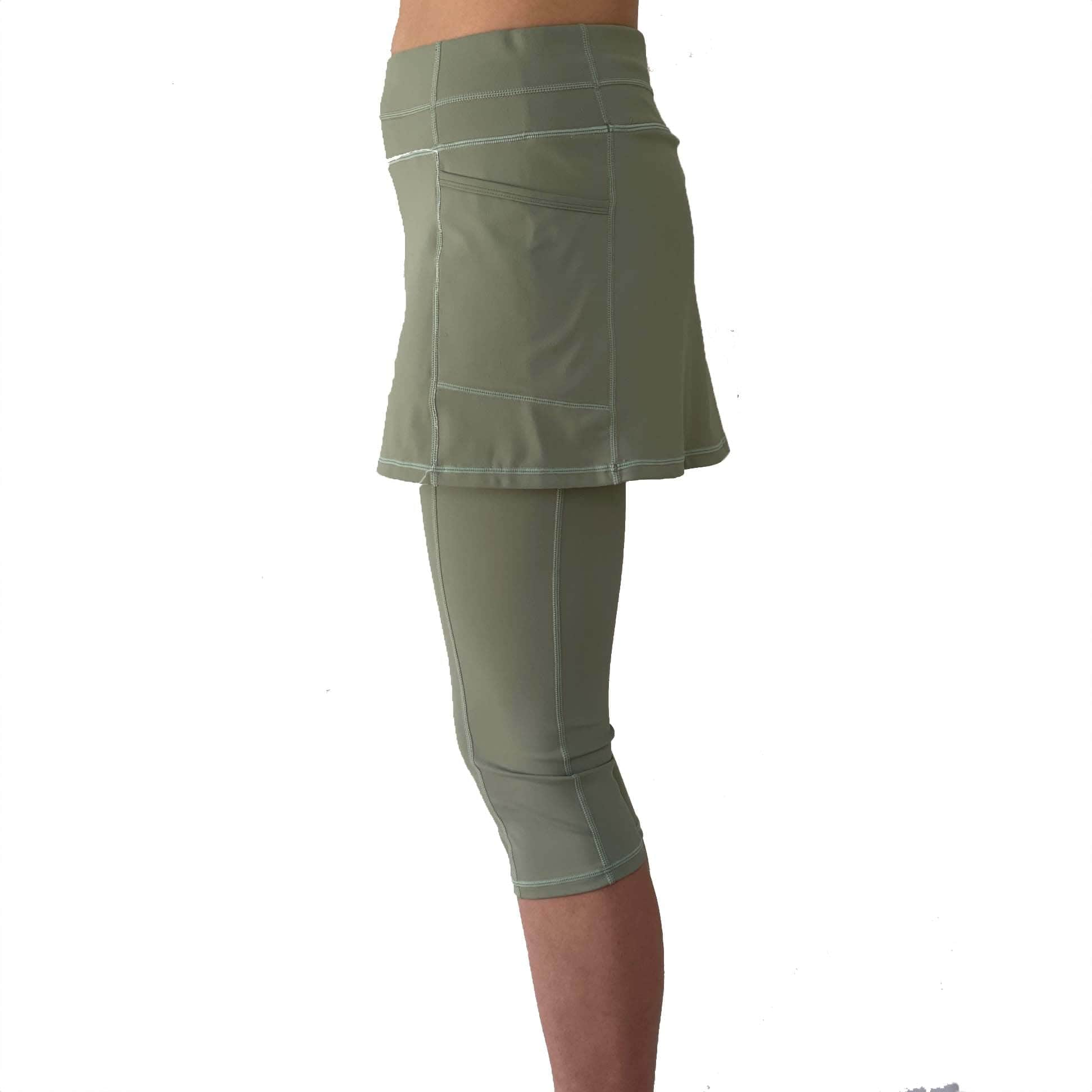 Studio shot waist down of model wearing sage green skirted leggings  from side.