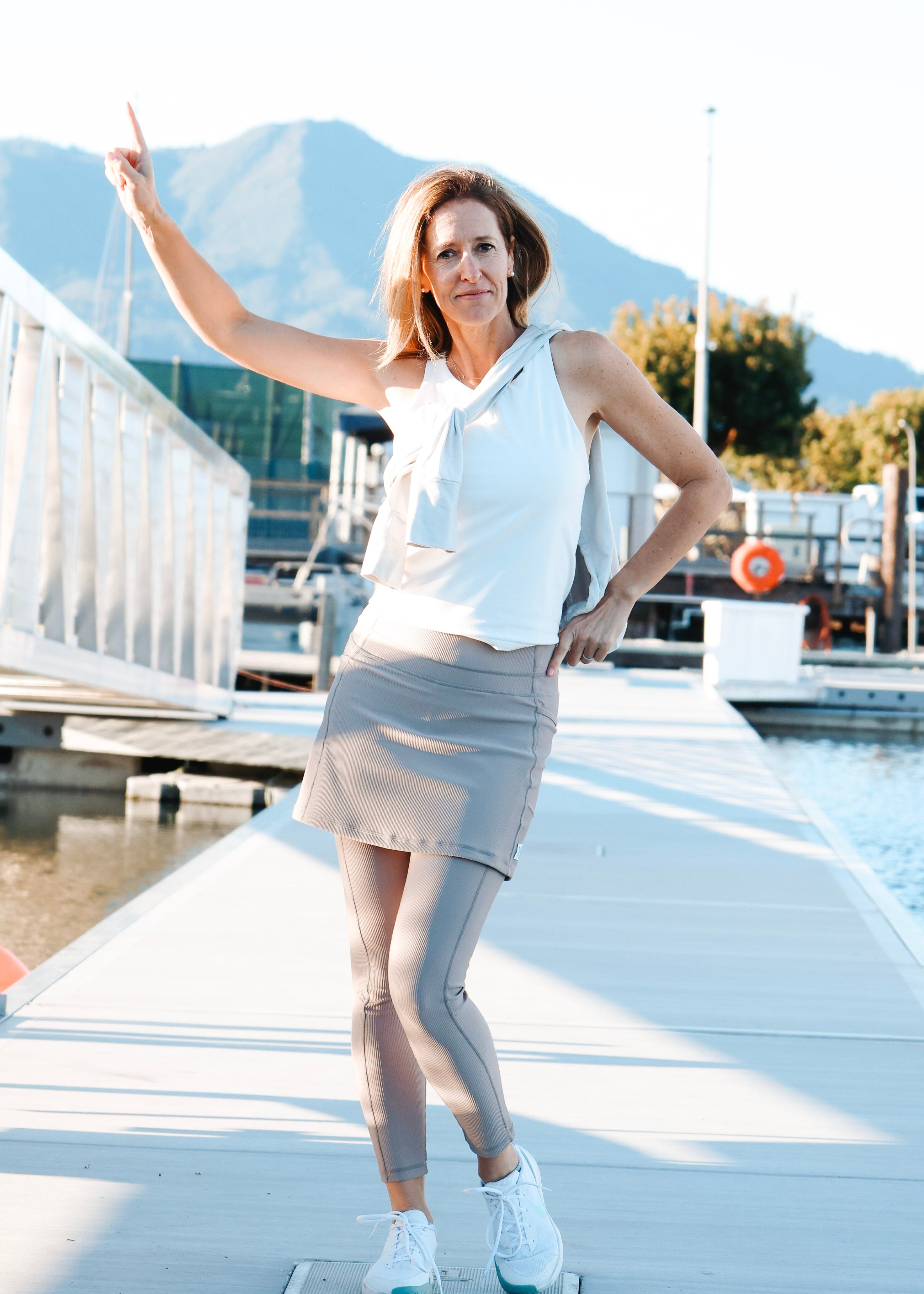 Woman standing on a dock with mountains in the background