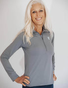 Close up shot of silver haired model wearing a pretty grey 1/4 zip athletic shirt.