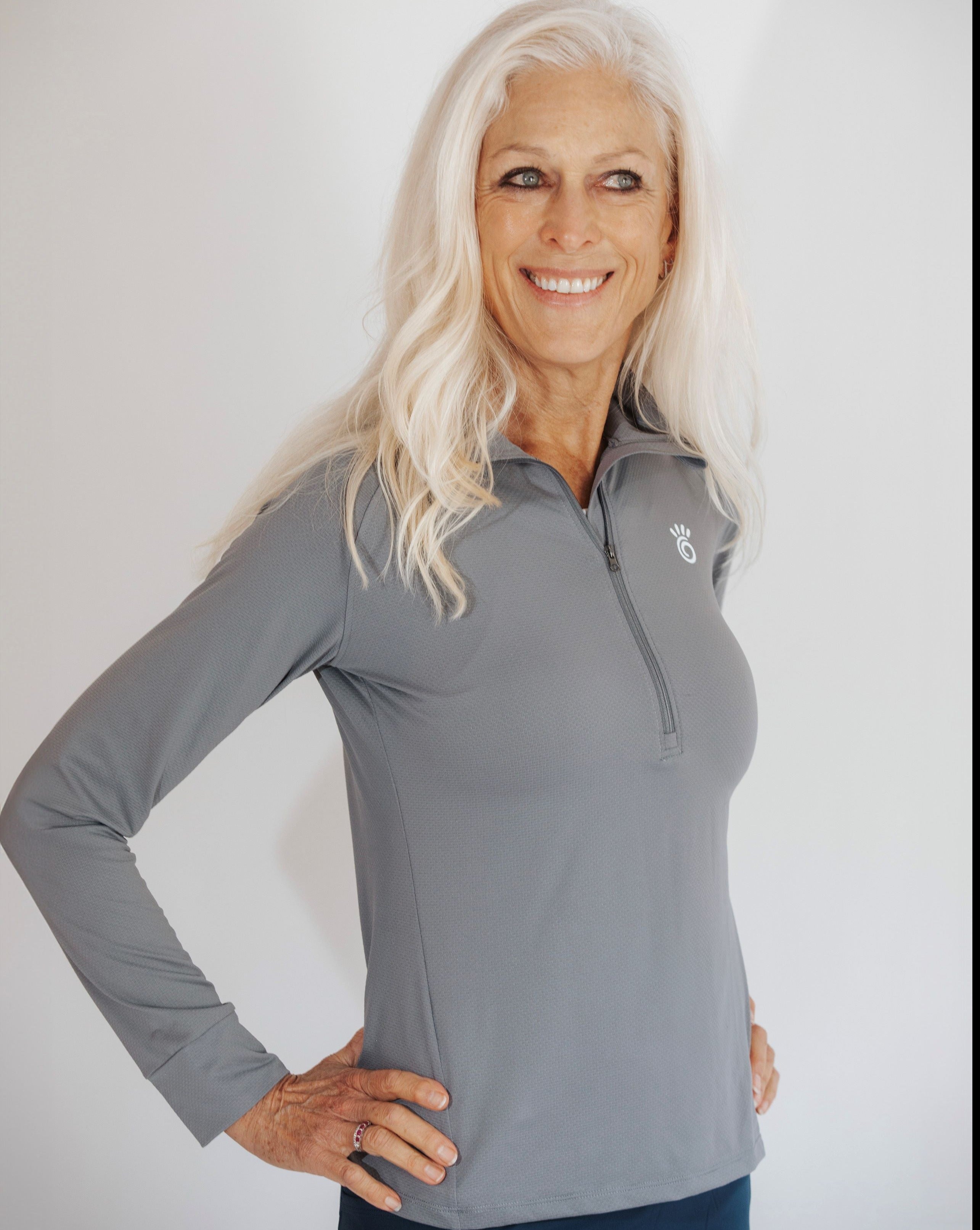 Close up shot of silver haired model wearing a pretty grey 1/4 zip athletic shirt.