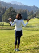 2-1 Original Skirted Mid-calf Length Leggings in Navy Blue - Model holding Golf Club looking at course - Sol Sister Sport