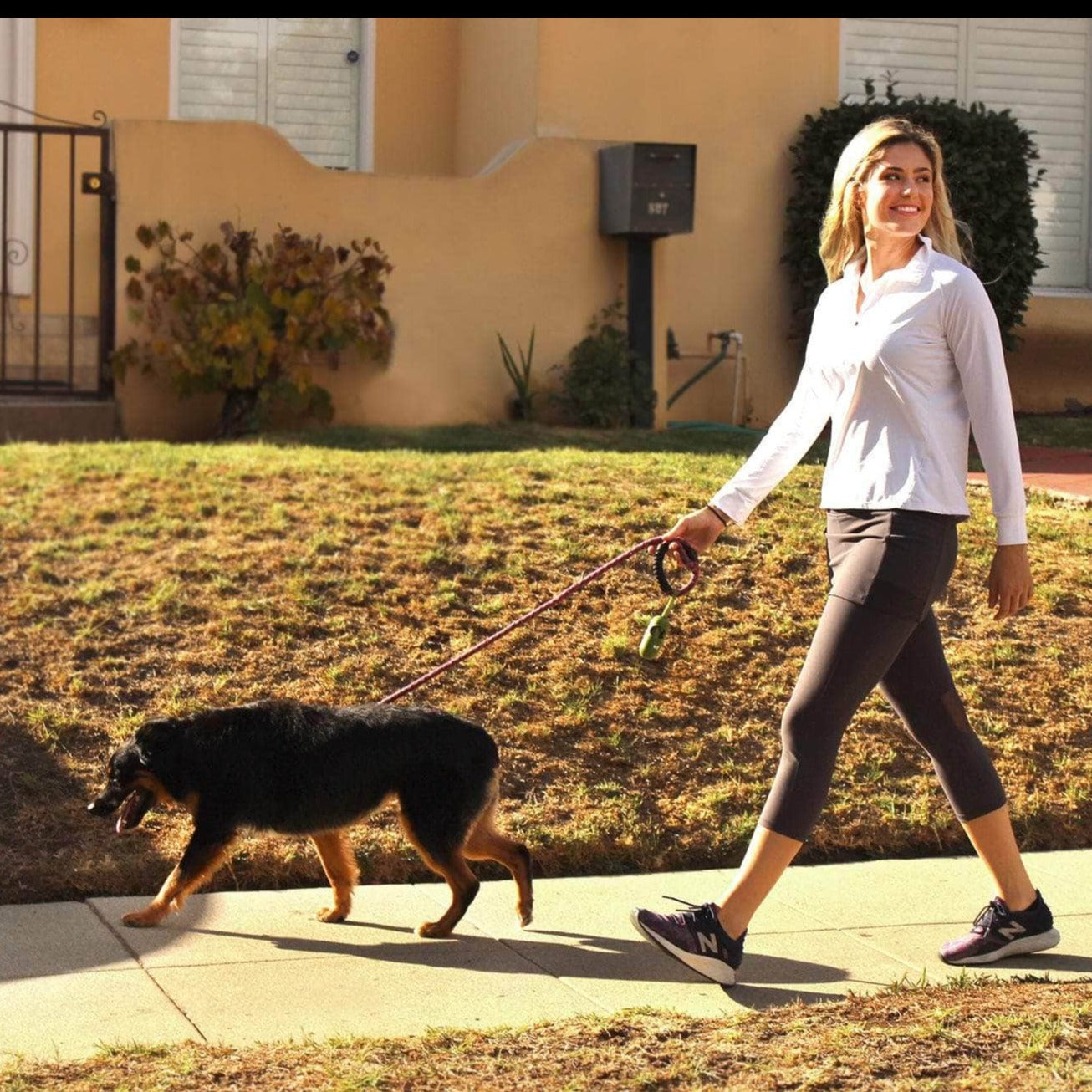 Model walking dog while wearing 2-1 Original Skirted Mid-calf Length Leggings in Steel - Sol Sister Sport